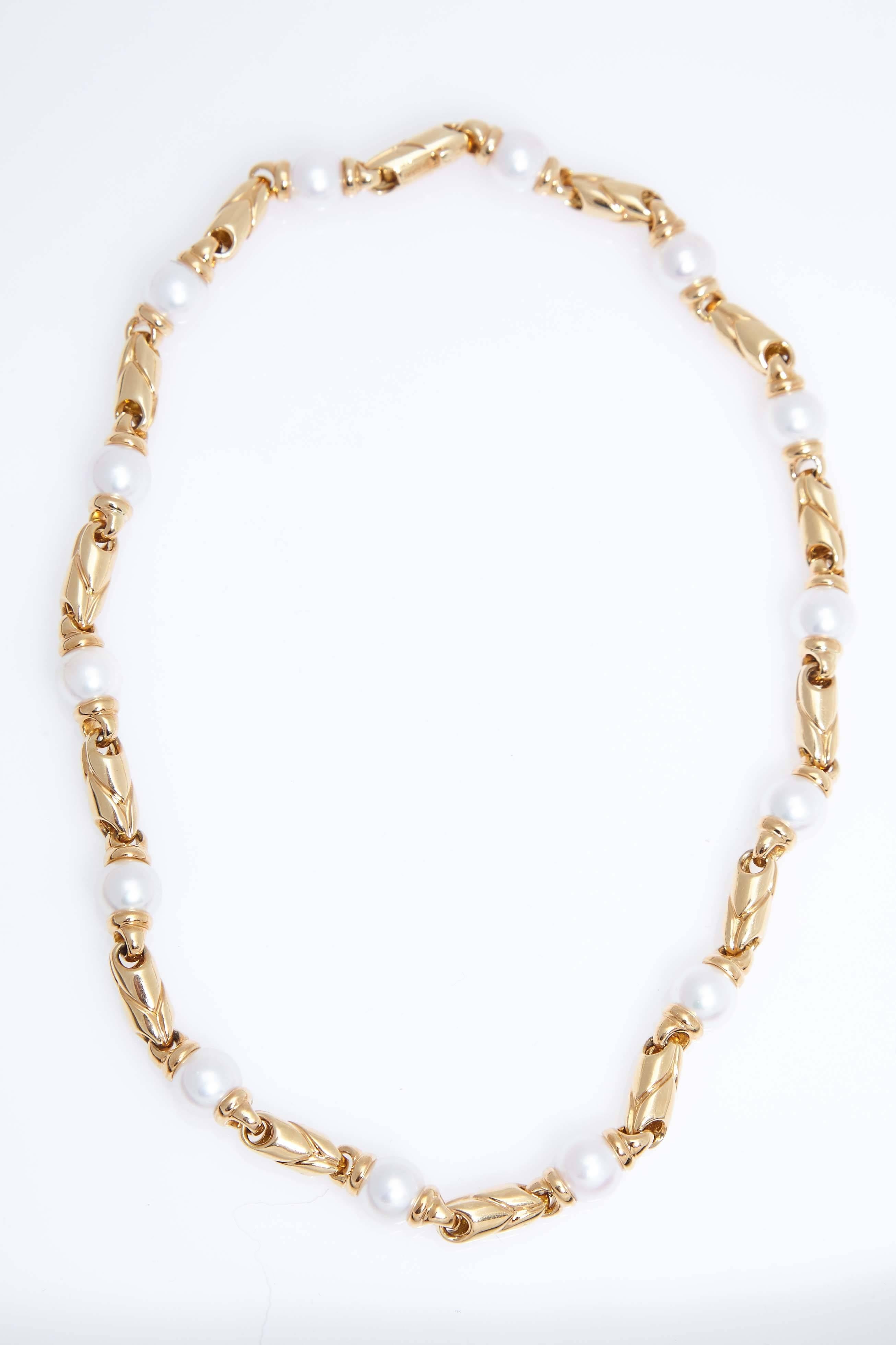 Bulgari 18 karat yellow gold and cultured pearl link necklace. The necklace contains 14 pearls which are 8.8-8.9 mm in size. The necklace is 16 inches long.  The piece is stamped "BVLGARI, 750".