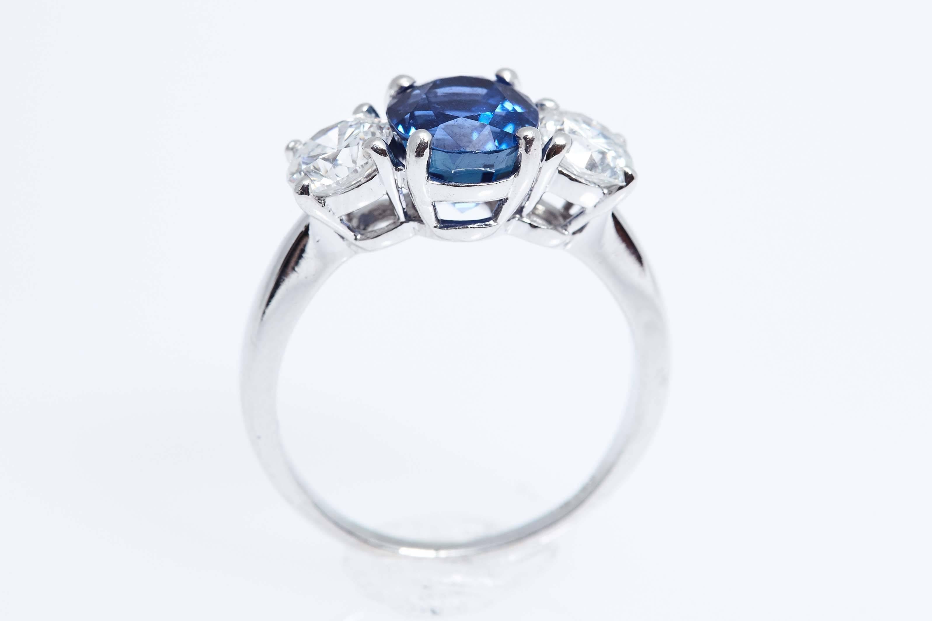 Platinum ring with a blue oval sapphire weighing 2.74 carats and 2 round diamonds with a total weight of approximately 1.20 carats.  The sapphire has a certificate from the American Gemological Laboratories stating that it has no heat treatment and