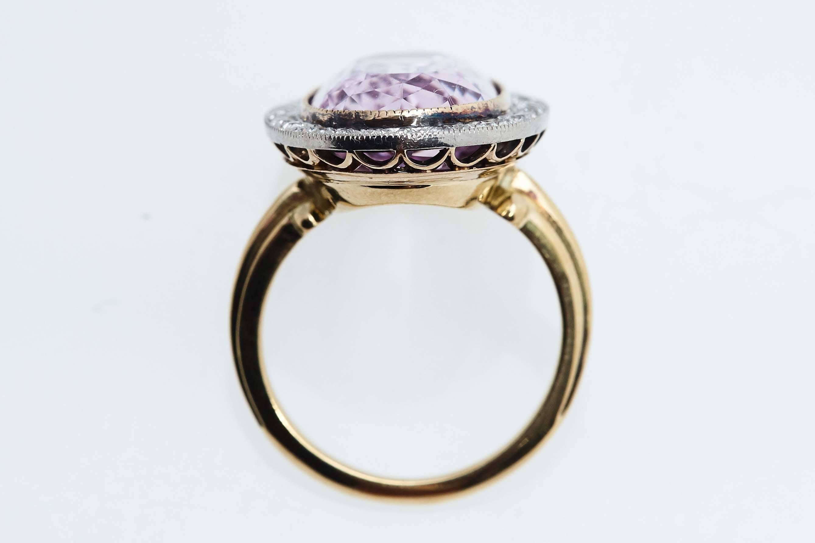 Edwardian pink topaz platinum and eighteen karat yellow gold ring with diamonds surrounding the topaz. The pink topaz has an estimate weight of 15 carats and the diamonds weigh approximately .30 carat.  The ring is a size 7 1/4 and the top measures