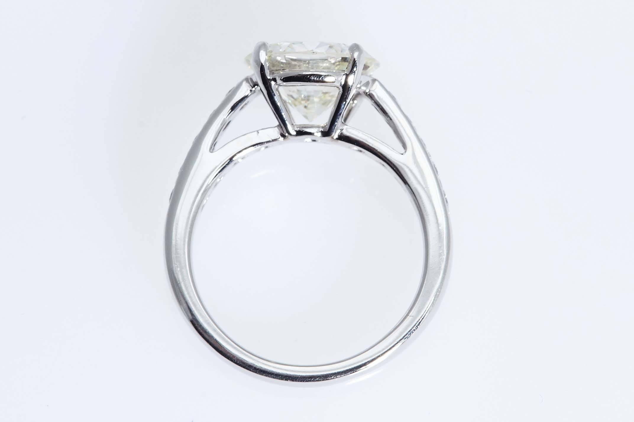Platinum engagement ring with a diamond weighing 3.01 carats. The center diamond has a certificate from the Gemological Institute of America stating that it is "I" in color and "VS2" in clarity.  The platinum ring has 10 smaller