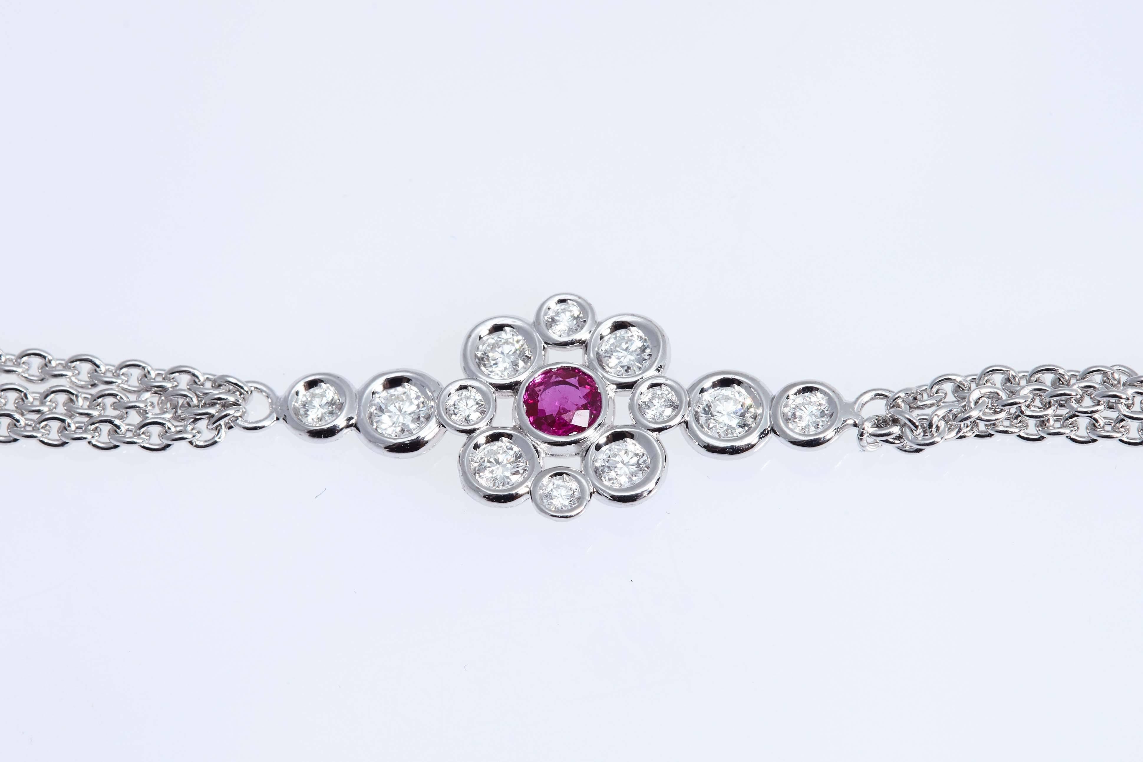 Eighteen karat white gold necklace made up eight flower motifs. Each motif has a ruby in the center surrounded by round diamonds. The necklace is 35 inches long and is made up of 105 round diamonds and 8 round rubies.
