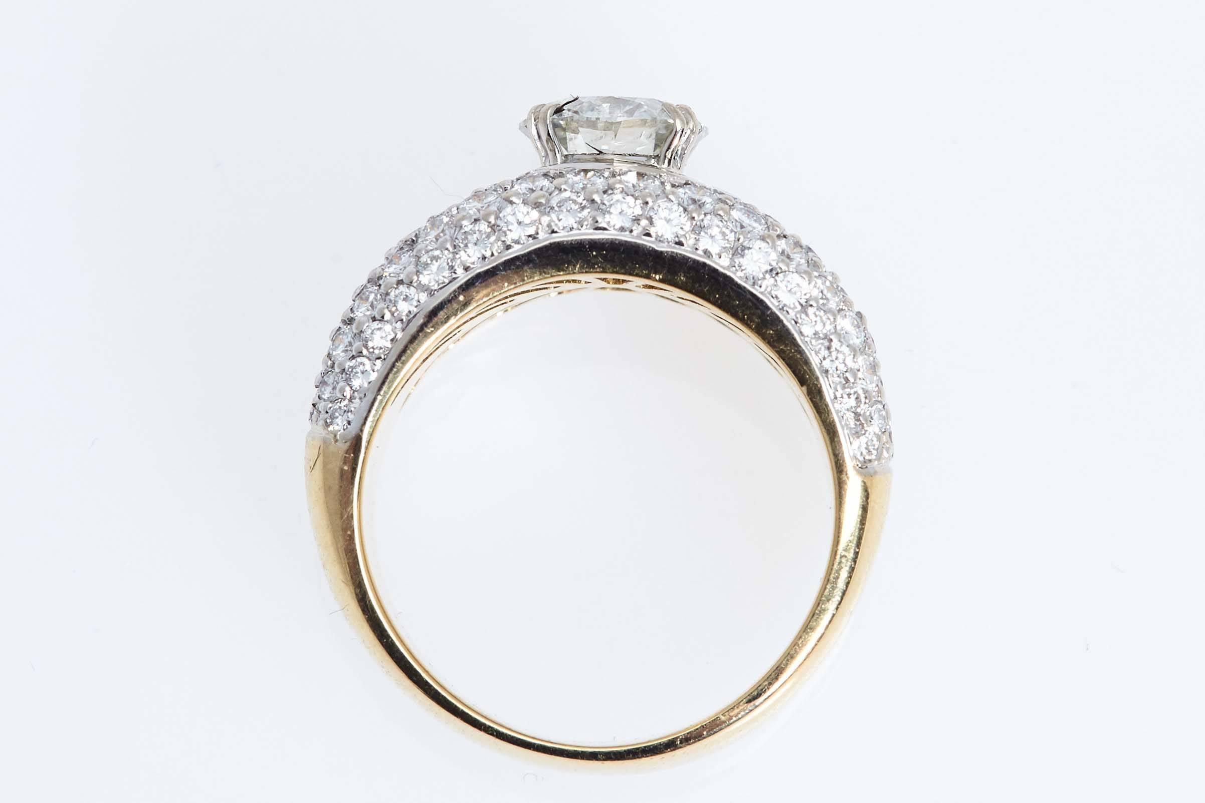 Eighteen karat white and yellow gold diamond ring. The ring looks as if you have two bands of diamonds with a round diamond in the center weighing 1.41 carats.  There are 118 smaller diamonds weighing approximately 2.00 carats set into the bands.