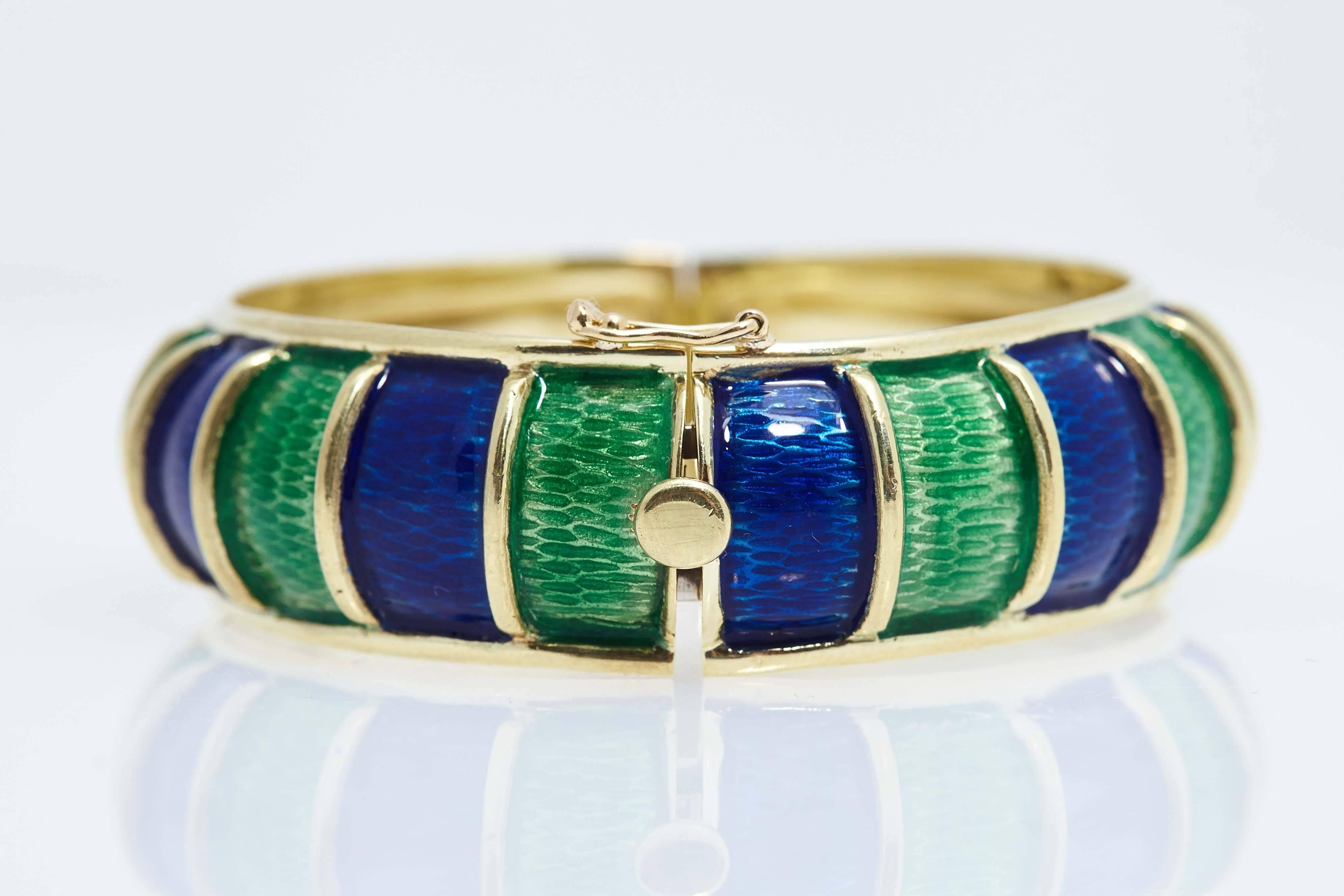 Cellino blue and green enamel bangle in eighteen karat yellow gold. The bangle will fit size is 6 3/4" wrist. The piece is marked "Cellino" and "18k".  The piece is  2 5/8 inches wide.