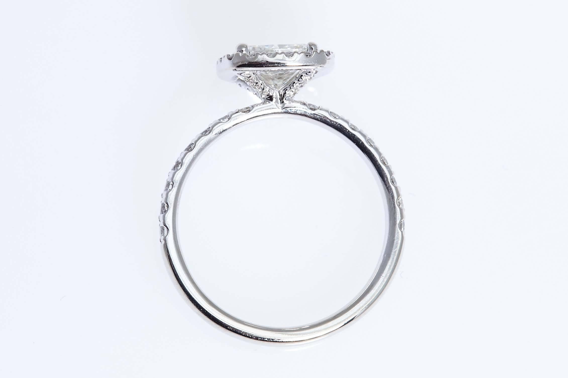 Cushion shaped diamond weighing 1.50 carats mounted in a 14 karat white gold ring with twenty round diamonds encircling the center diamond weighing approximately .20 carat and sixteen round diamonds mounted into the shank weighing approximately .24