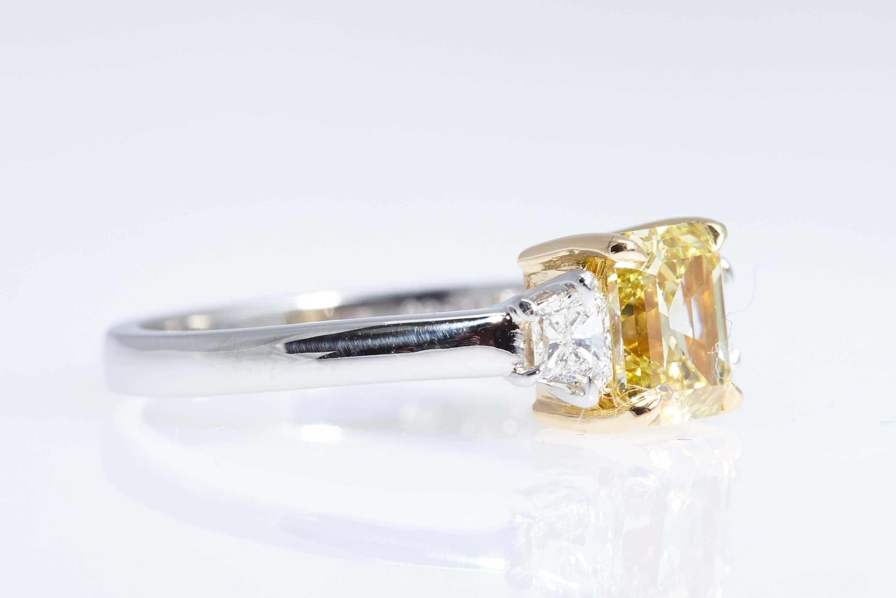 This emerald cut diamond weighs 1.62 carats and has a GIA certificate stating that it is "Fancy Intense Yellow" and "VS1" in clarity.  The ring is platinum with the center stone mounted in eighteen karat yellow gold. The center