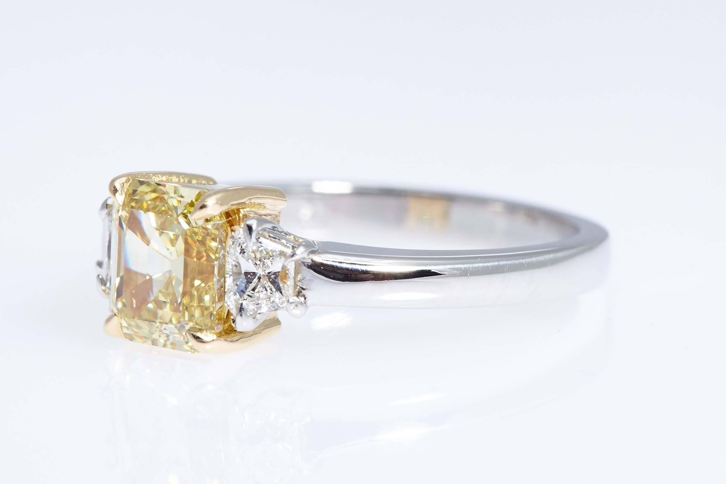 Modern GIA Intense Yellow 1.62 Carat Emerald Cut Diamond Platinum Three-Stone Ring For Sale