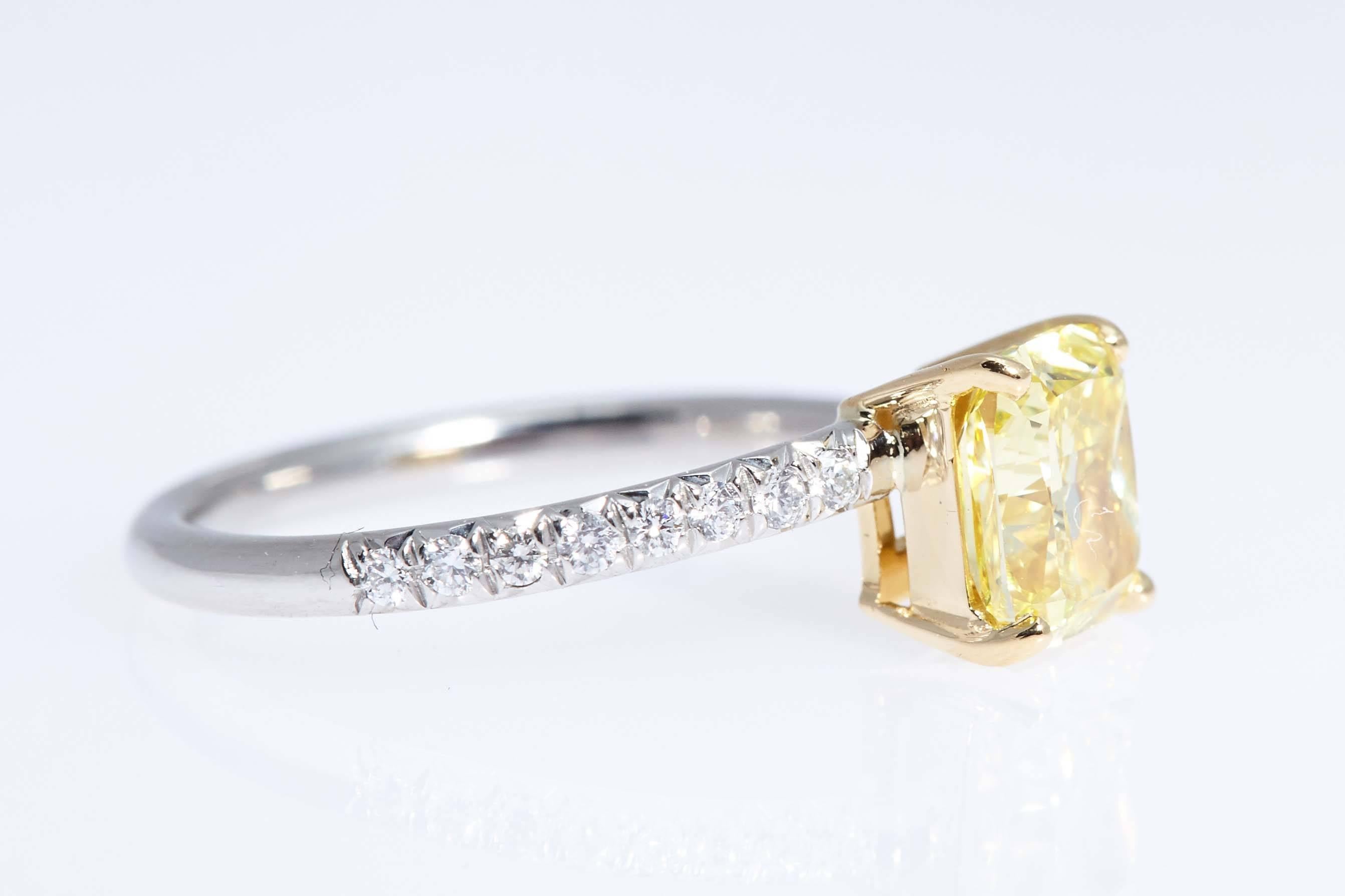 Vivid Yellow color and "VS1" clarity cushion shaped diamond weighing 1.39 carats graded by the Gemological Institute of America.  The center is mounted in platinum and 18 karat yellow gold ring. The ring is special in that the shank is off