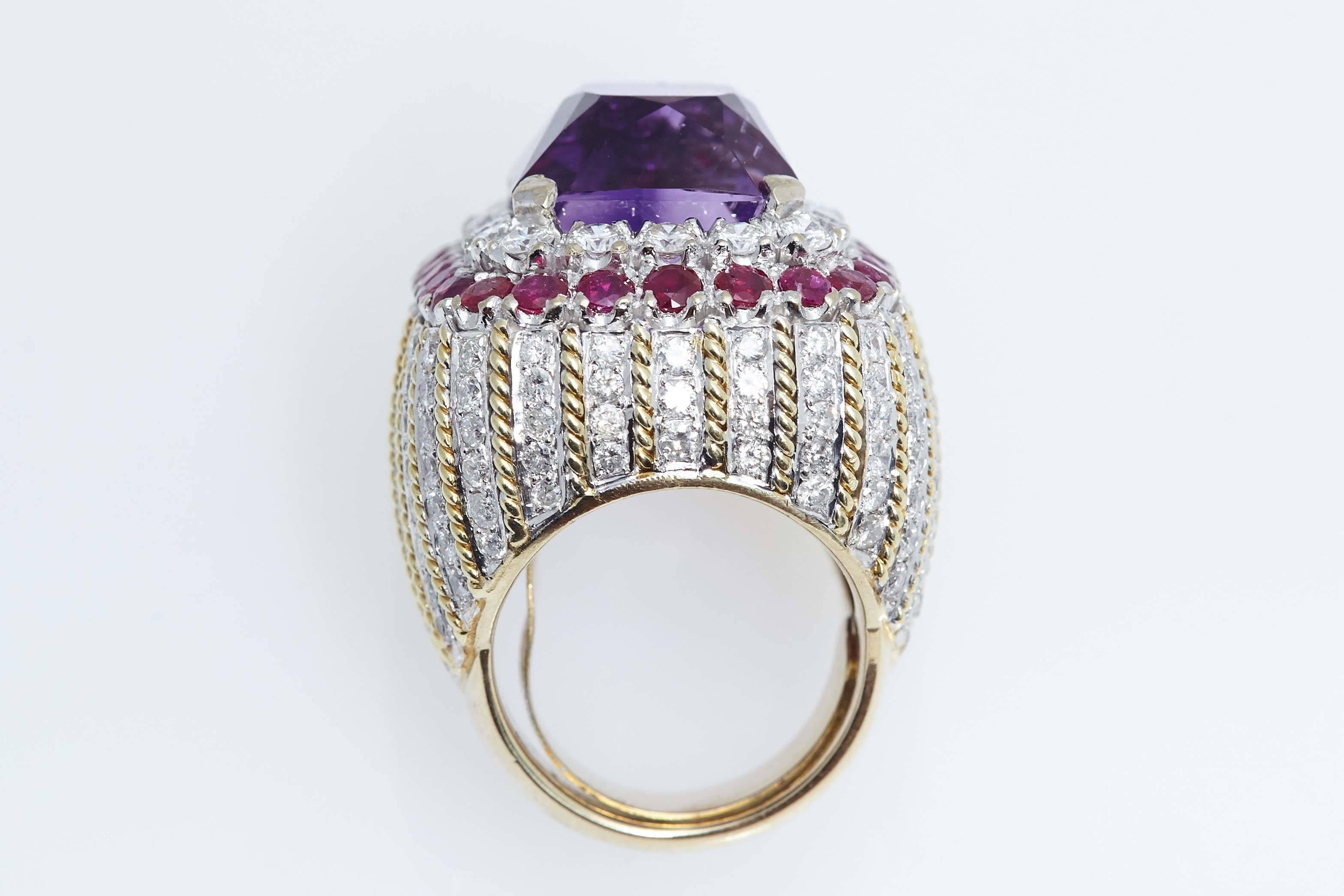 An Amethyst, Ruby, diamond fourteen karat bi-color gold cocktail ring.  The ring contains approximately 6.00 carats of round diamonds accented by 28 rubies weighing approximately 3.00 carats. The ring is size 7.