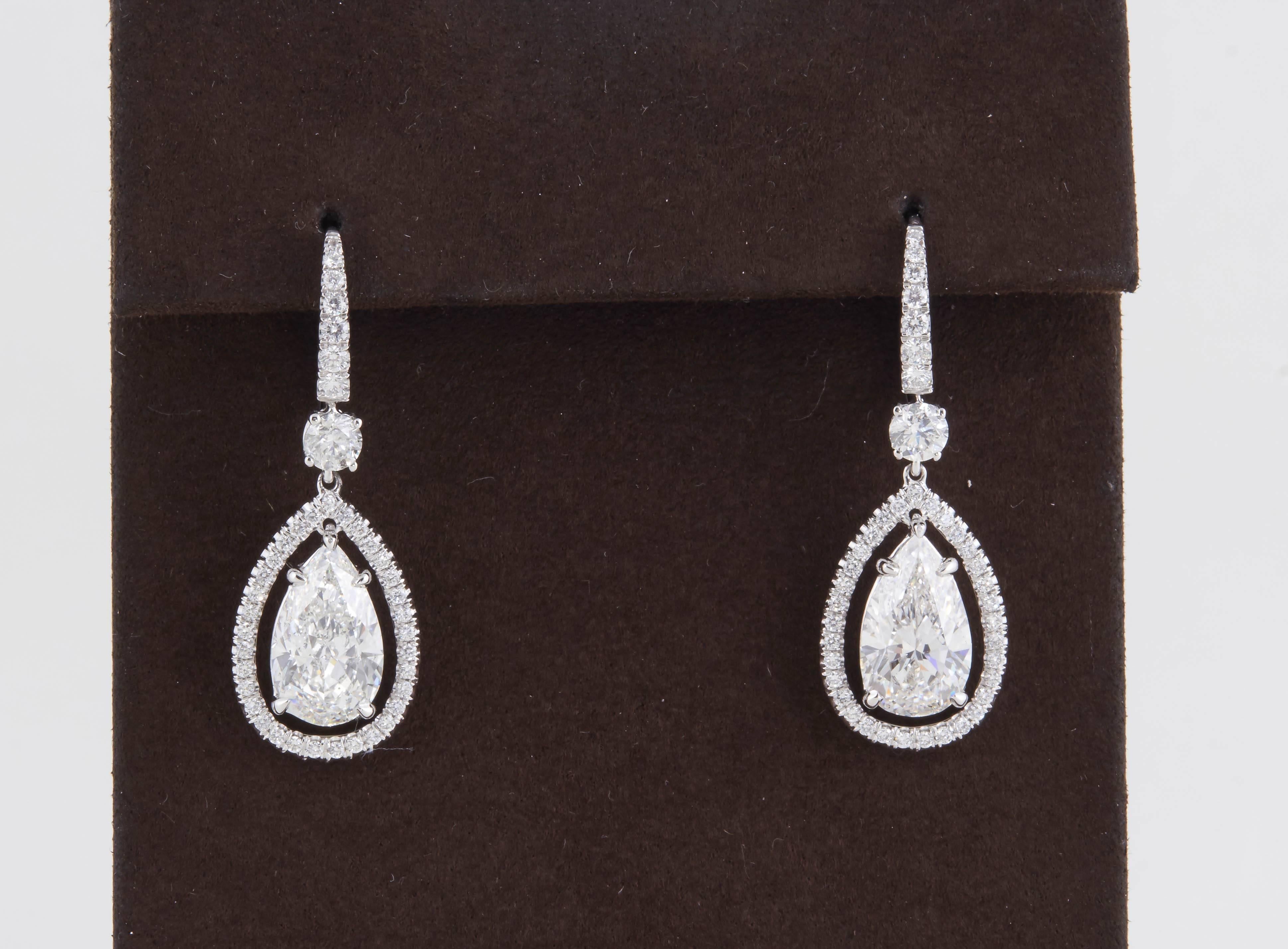 

An exceptional pair of earrings featuring two 3 carat each, high quality GIA certified pear shape diamond drops. 

The drops are set with 1.33 carats of round brilliant cut diamonds all G color VS clarity. 

Two pear shapes weighing a total of