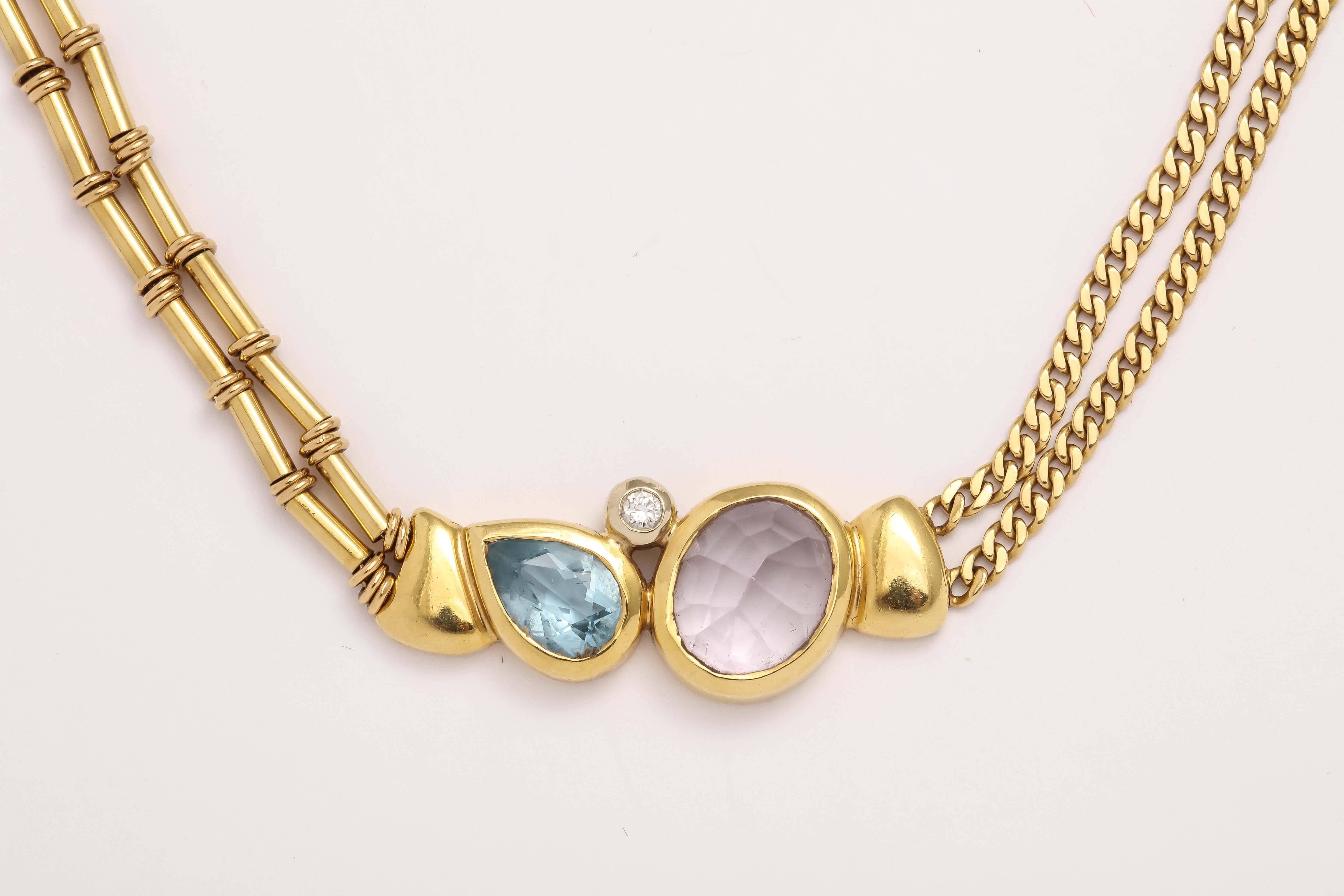 18kt Art form Necklace of  varying 18kt Yellow Gold chains and center set with a Pear shaped Blue Topaz and faceted  Kunzite  -  reverse set and foiled by a bezel set Diamond. Engraved Manfredi in Block Letters on the Clasp.