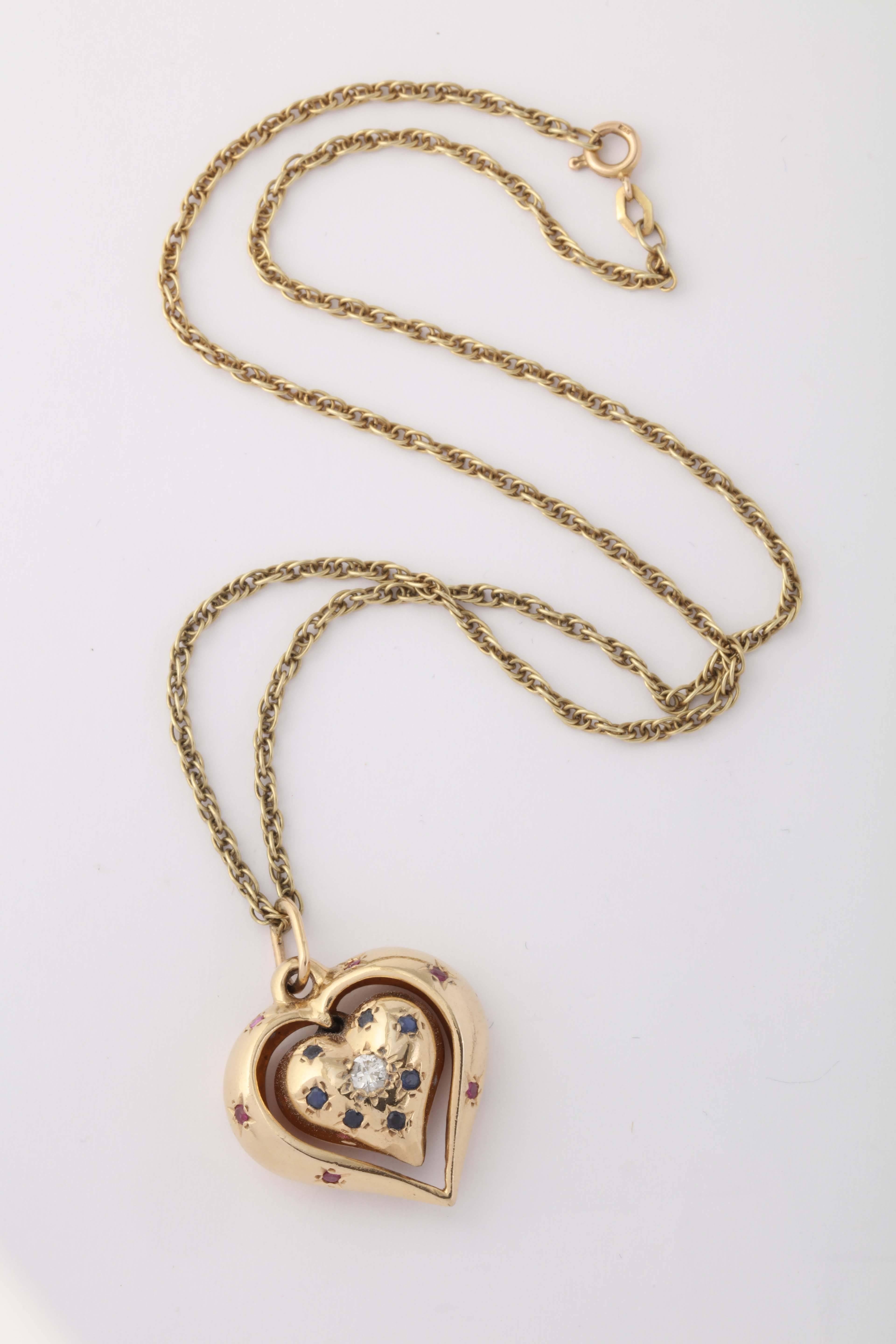 14kt Yellow Gold Reversible Puffy Three Dimensional Heart Pendant Embellished With Sapphires And Rubies And One Large Single Full Cut Diamond Weighing Approximately. 20 pts .All Stones Set In A Star Motif Setting Which Was Typical Of The Settings In