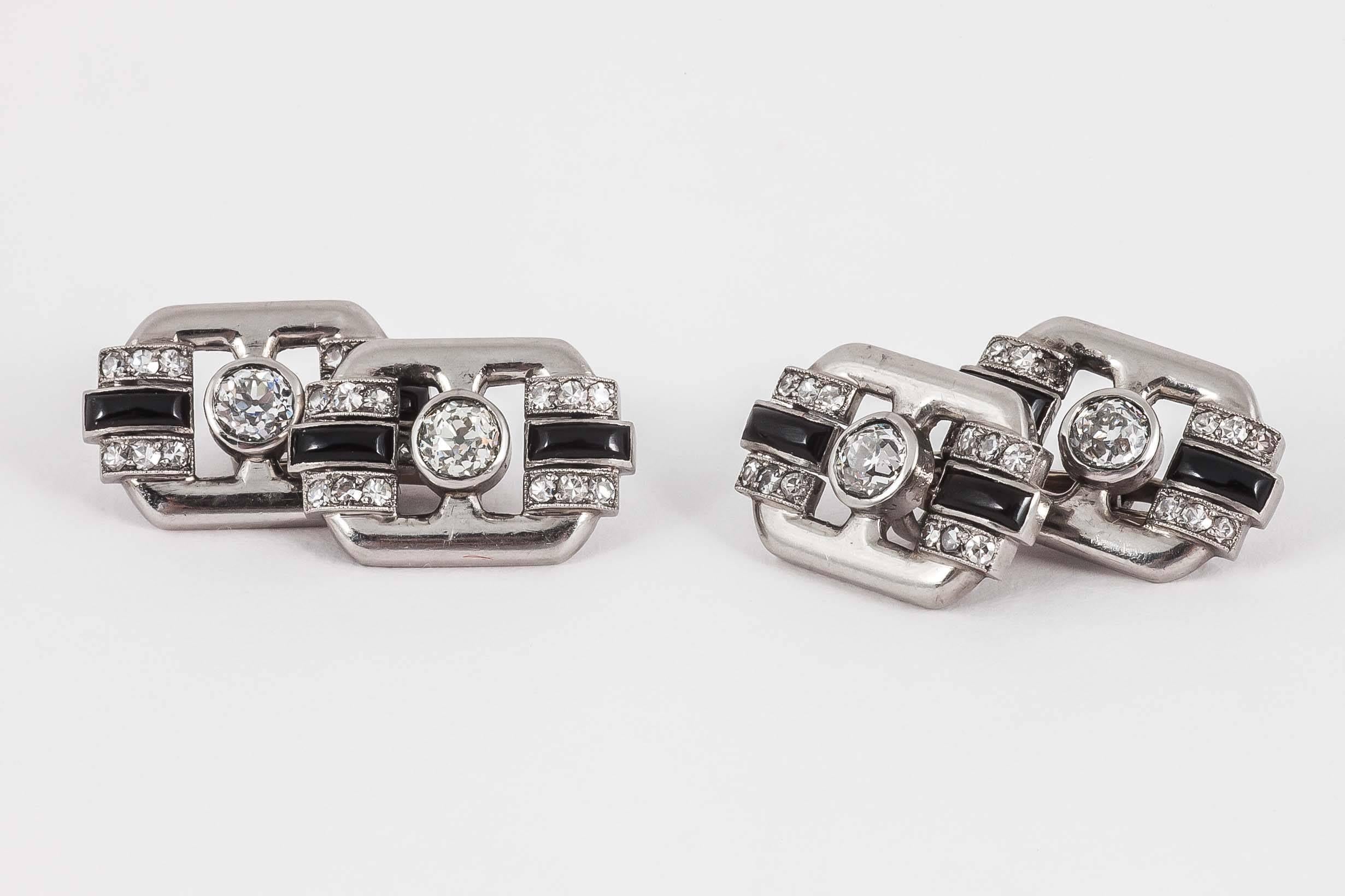 A heavy pair of platinum mounted cufflinks,of openwork,Art Deco period,with an old cut diamond centre,and onyx set at either end with three,small diamonds either side.French marked,c,1930-5