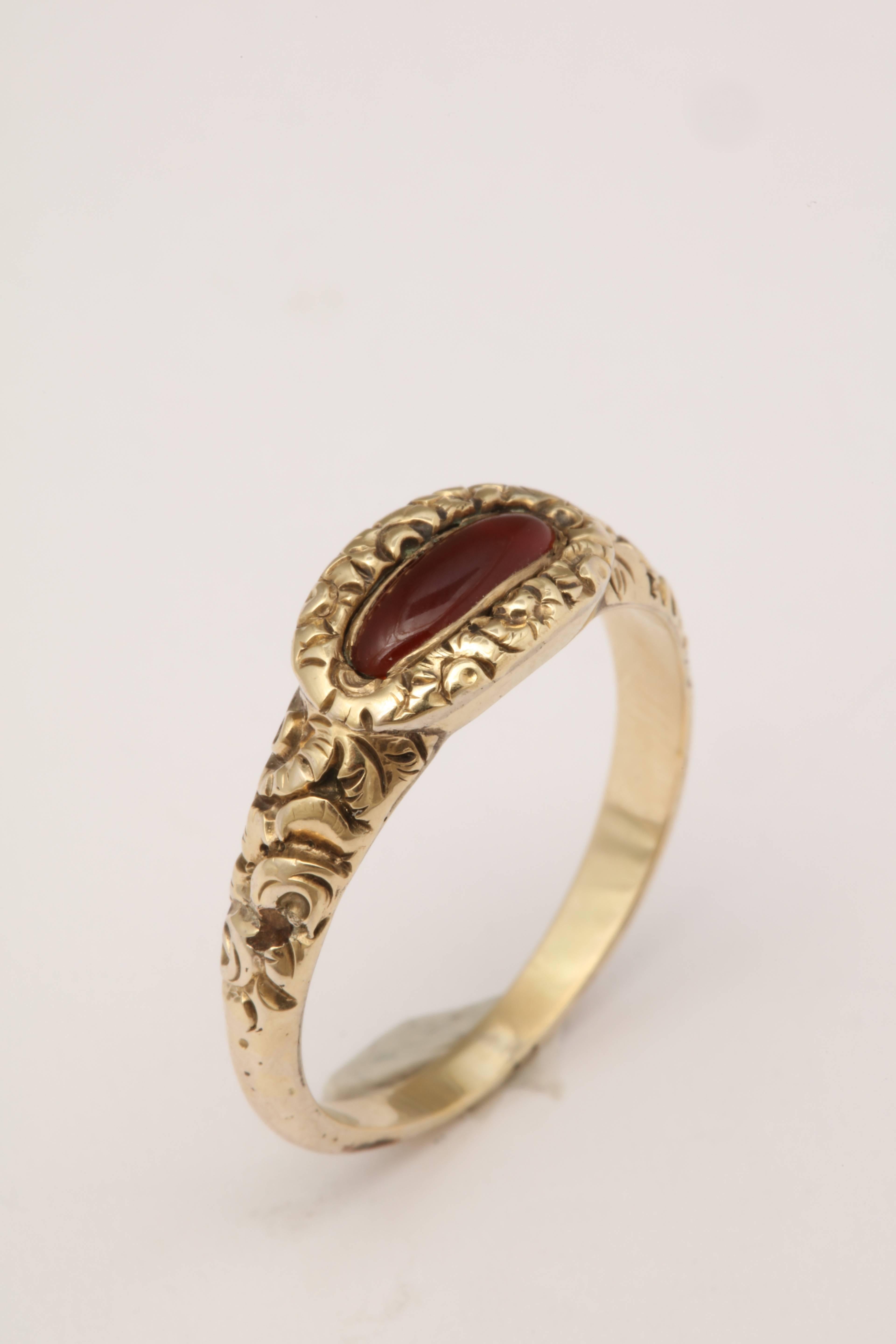 A lovely example of the Georgian style transferring into the Victorian period. This ring is 15kt and heavily engraved. It has a closed back setting with a dark red carnelian. 