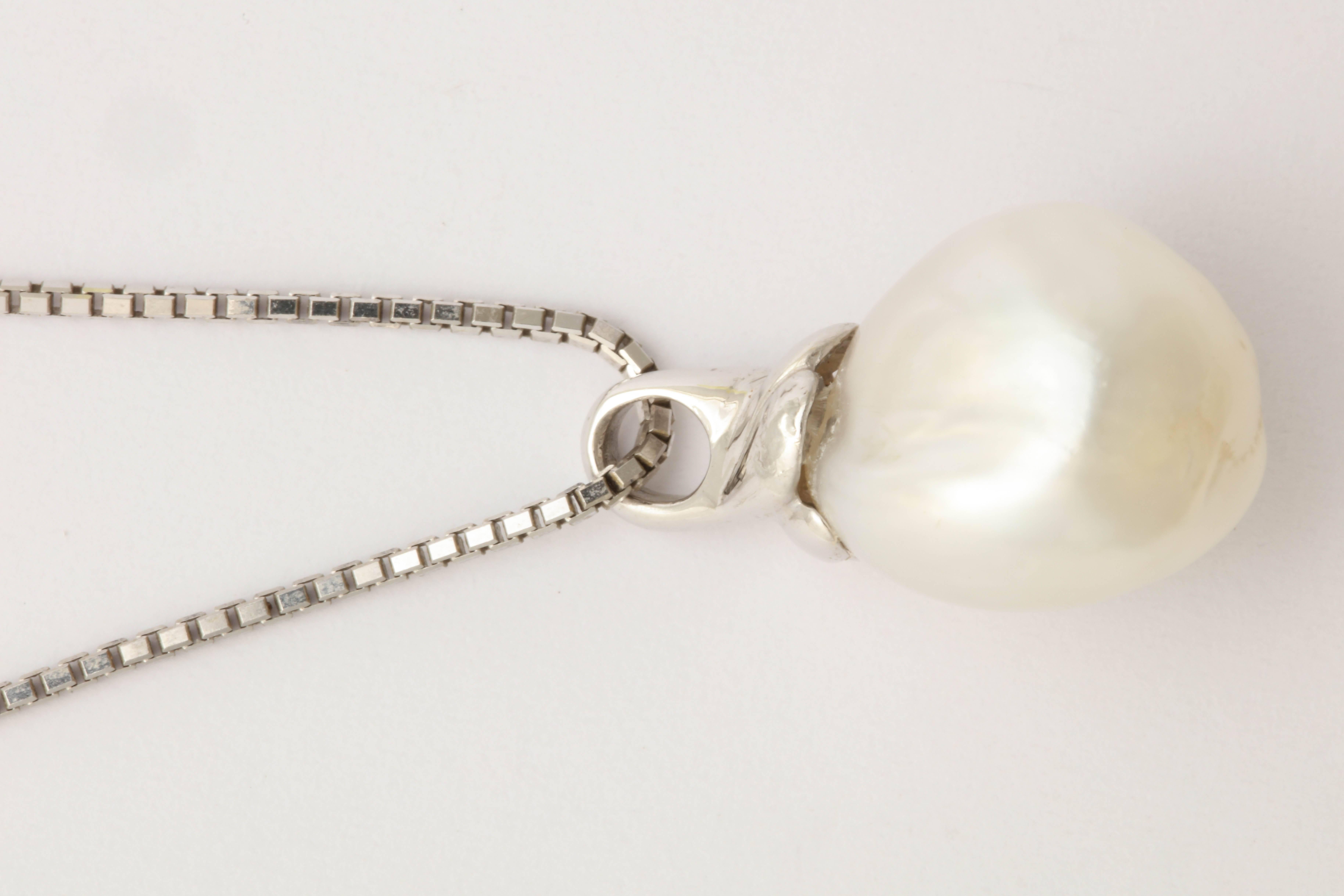 Elegant baroque South Sea pearl pendant topped with a lovely swirl of 14 kt white gold.  The luster of the  pearl is wonderful. The chain is a 16 in. box chain in 14 kt white gold.  Either can be bought separately 