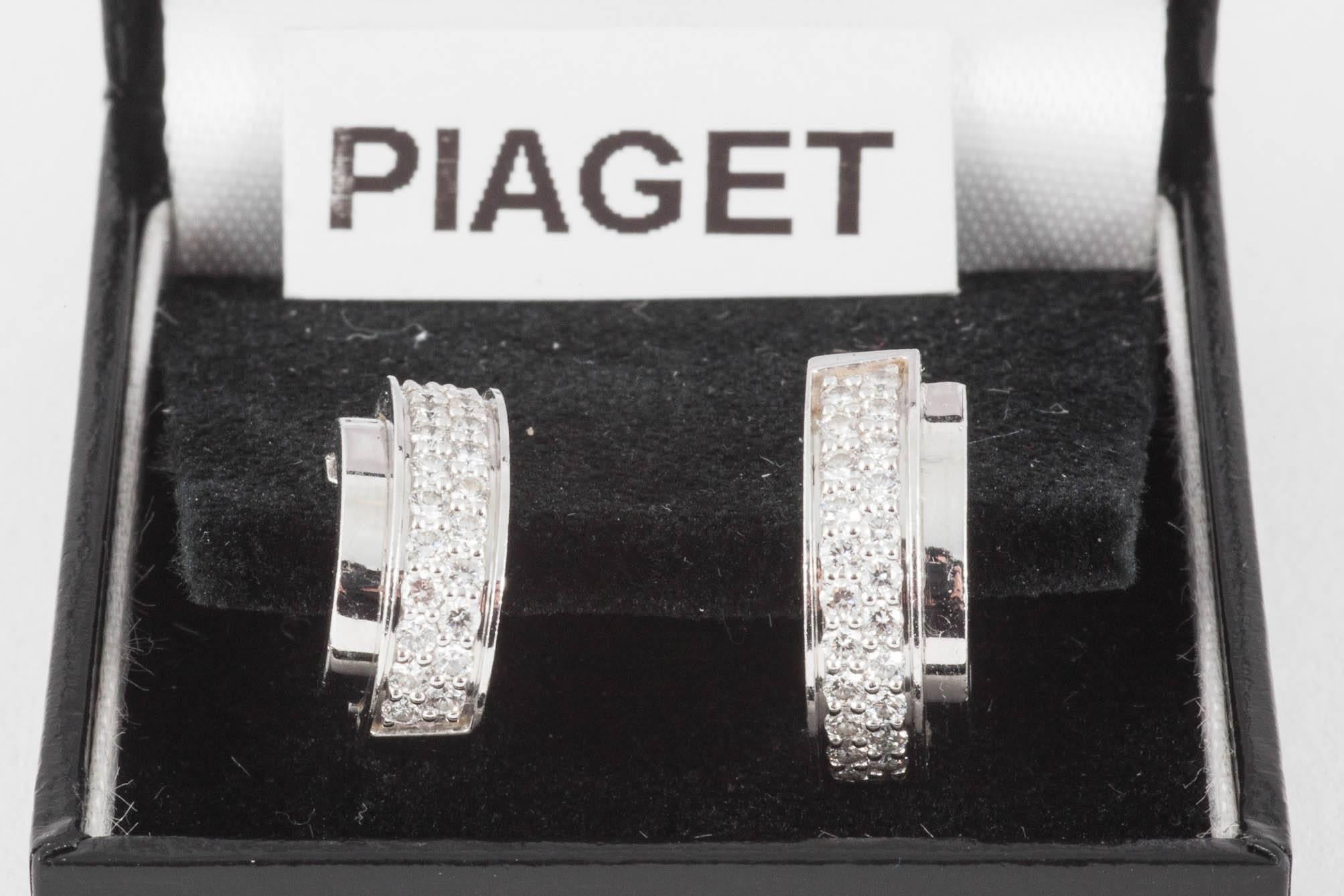 A pair of heavy 18 karat white gold creole shaped earrings with the central band to each earring set with 26 small brilliant cut diamonds. Peg fitting with a clip fastening. Signed Piaget with a 750 mark for 18 karat gold. Numbered D30314
Measures