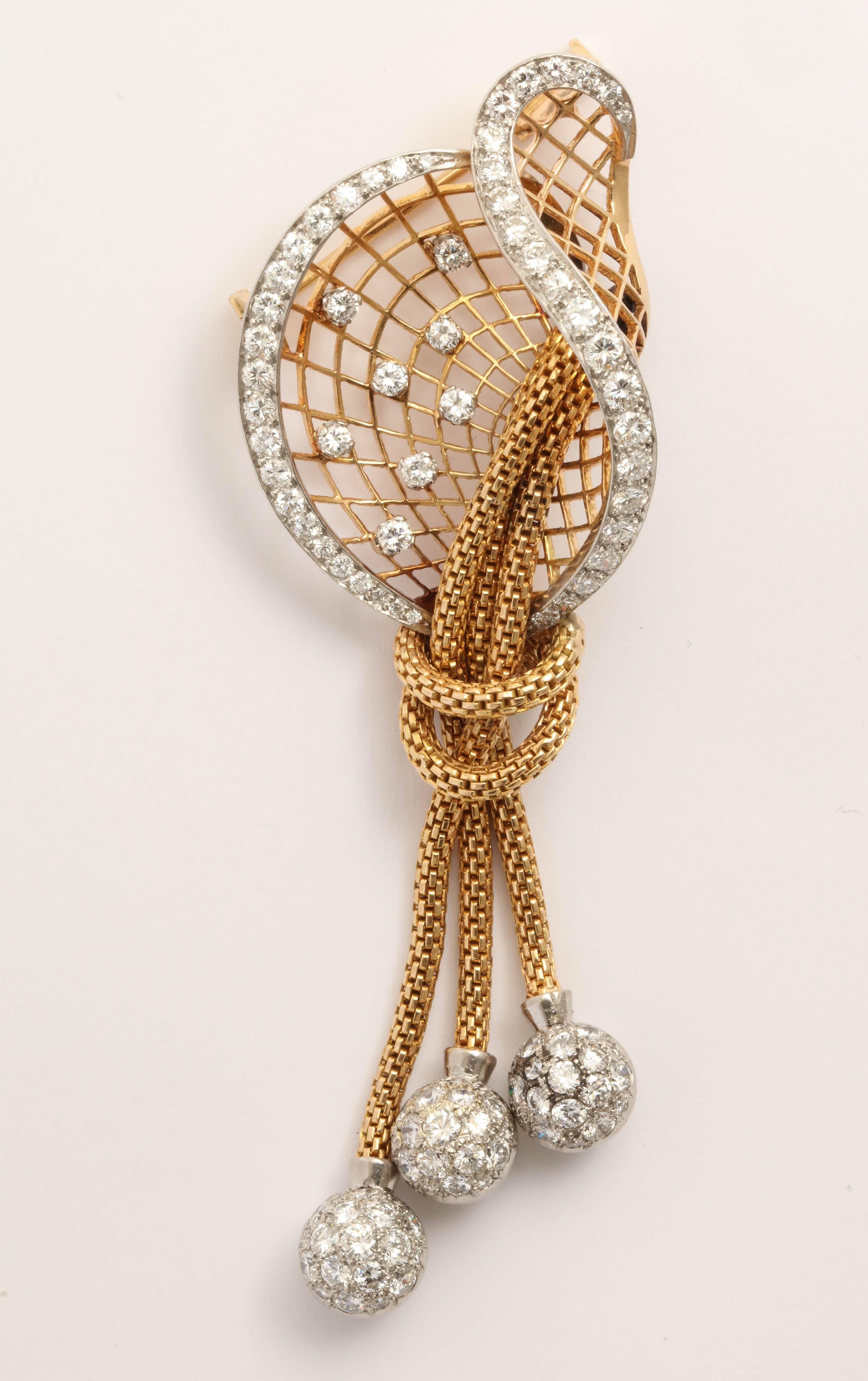 Stylistically strong Diamond & platinum & 18kt YellowGold Brooch. Combination of 3 braided drops ending in platinum & pave Diamond set balls descending from an expanding pierced fan of Gold that is criss crossed between 2 undulating rows