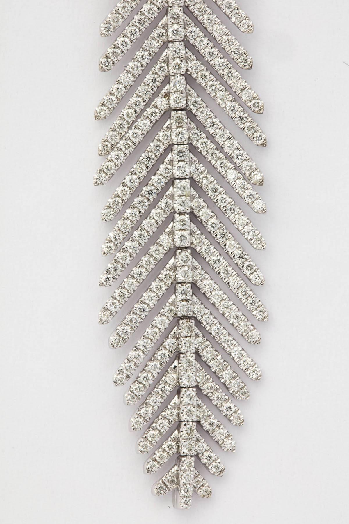 18k white gold and diamond flexible feather earrings measuring 3 inches
 in length. Each section moves independently creating a sensual feel. The earring is set with 562 full cut diamonds weighing almost 3.00 ct.