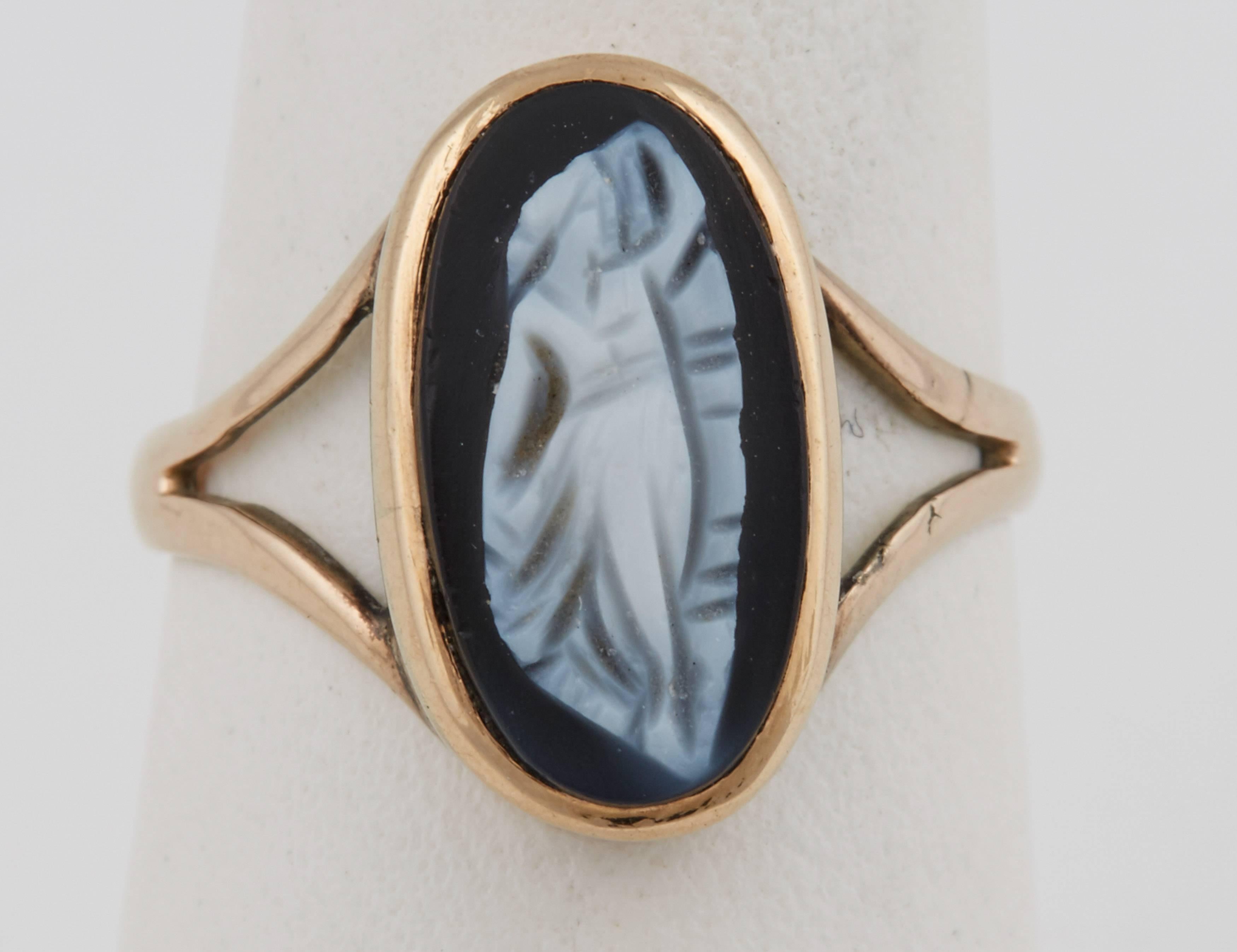 Set with an oval agate cameo of a full-length dancing maiden, in a bezel mount of yellow gold typical of the period.

Mid 19th century, English or American 

Size 4 ½. Cameo 14 x 7 mm bezel set measures 5/8 in. (1.6  cm.) long; 1/8 in, ( .5 cm) high
