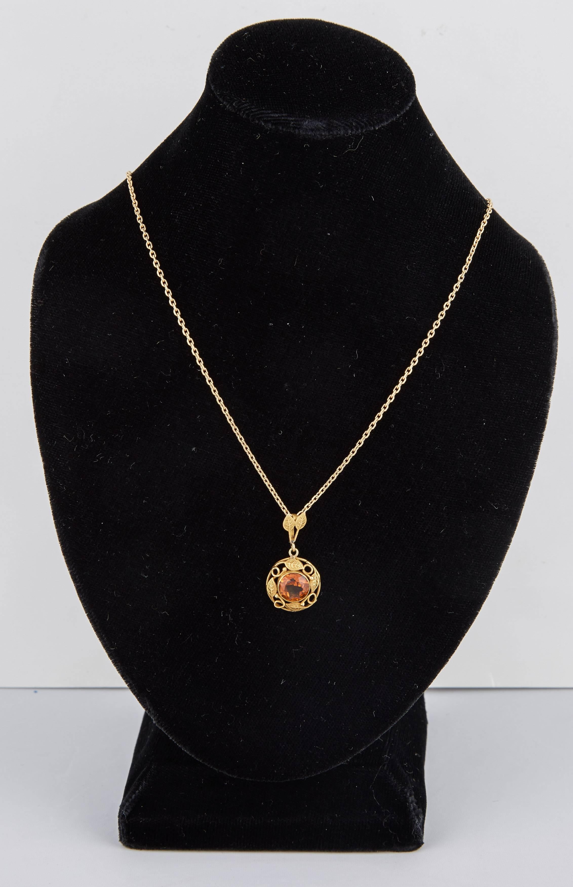This beautiful American Arts & Crafts pendant dates from around 1910 and was made in Boston. The circular 14k gold pendant set with a faceted citrine, enhanced with gold openwork vines, the suspension ring of similar design. Chain not included.