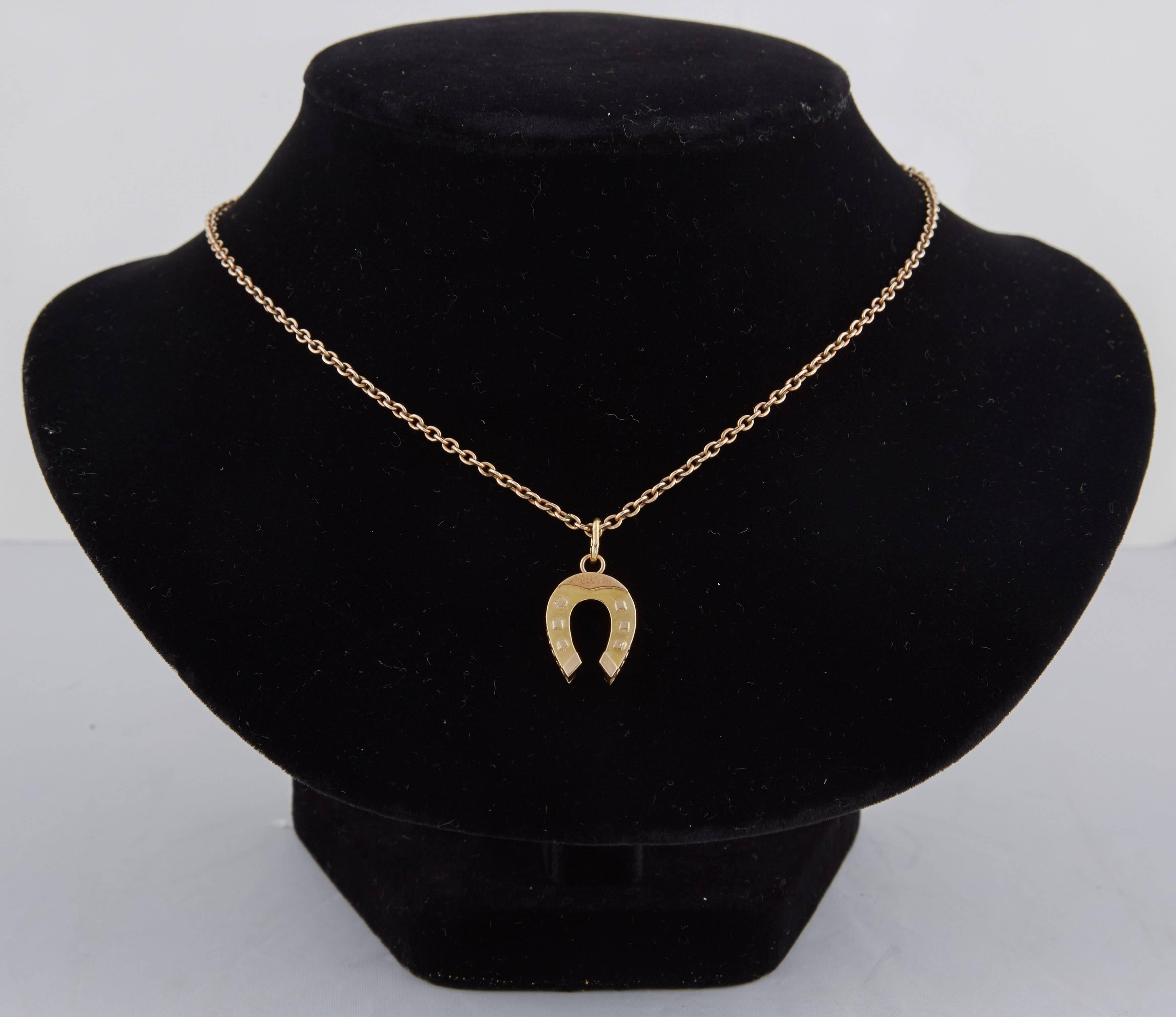 From the Romanov era, period of Tsar Nicholas II, a rare Russian 14k gold pendant designed as a horseshoe for good luck, of two-toned gold, the body matte yellow gold, the details polished rose gold, with openwork sides typical of the time.

With