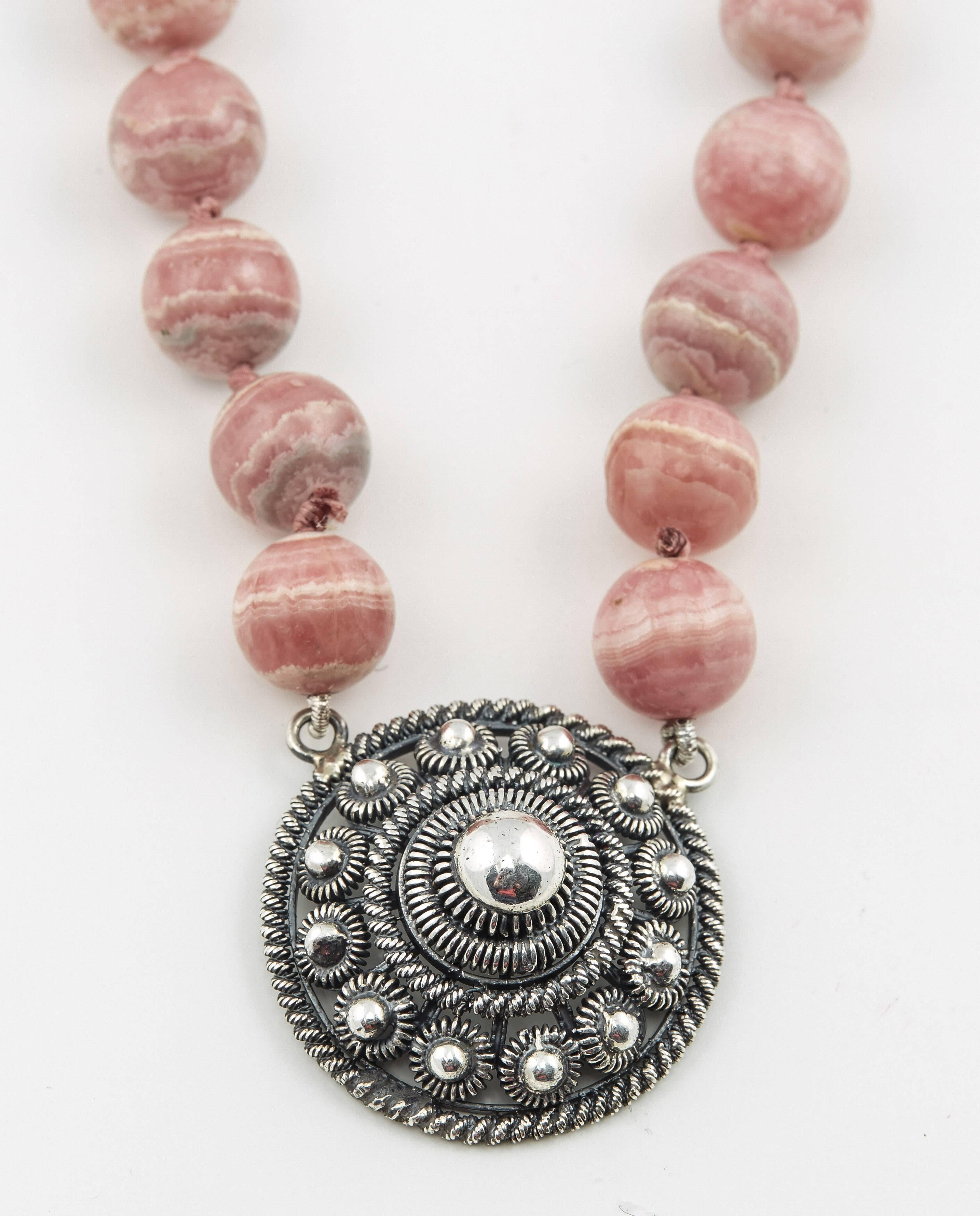 Distinctive necklace consisting of sixty five natural rhodochrosite beads attached to a filigree silver pendant, with a silver clasp. 

20th century

28 in. (71.1 cm.) long, the pendant, 1 ¼ in. (3.2 cm.) diam.   

Found in Russia and elsewhere,