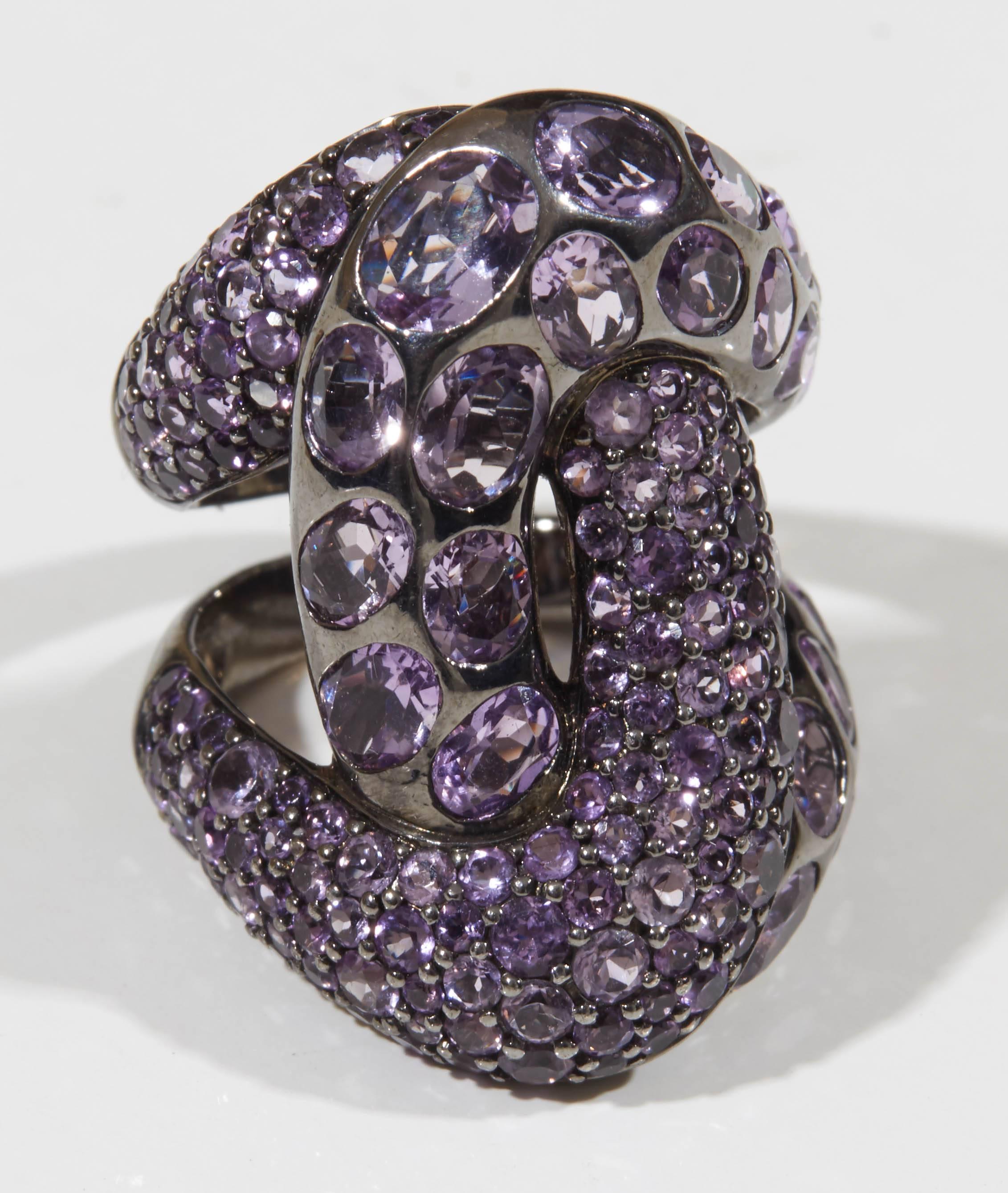 A rhodium plated sterling silver and 18kt yellow gold knot ring. The ring is set with 6.80cts of amethysts. Size 6.50
Length: 1.25 inches
Width: .75 inch