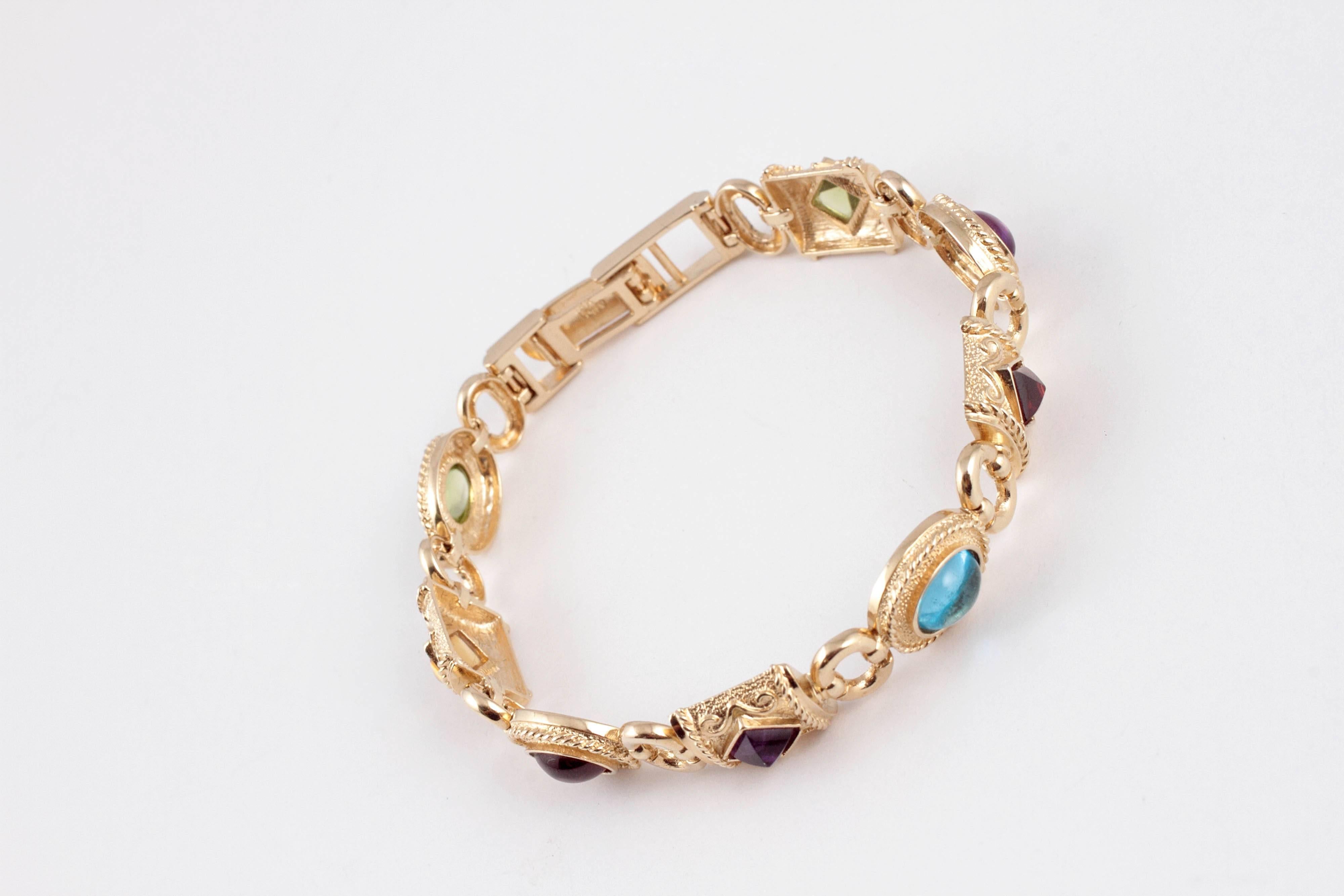 In 14 karat yellow gold, with bezel-set gemstones.  7 inches in length