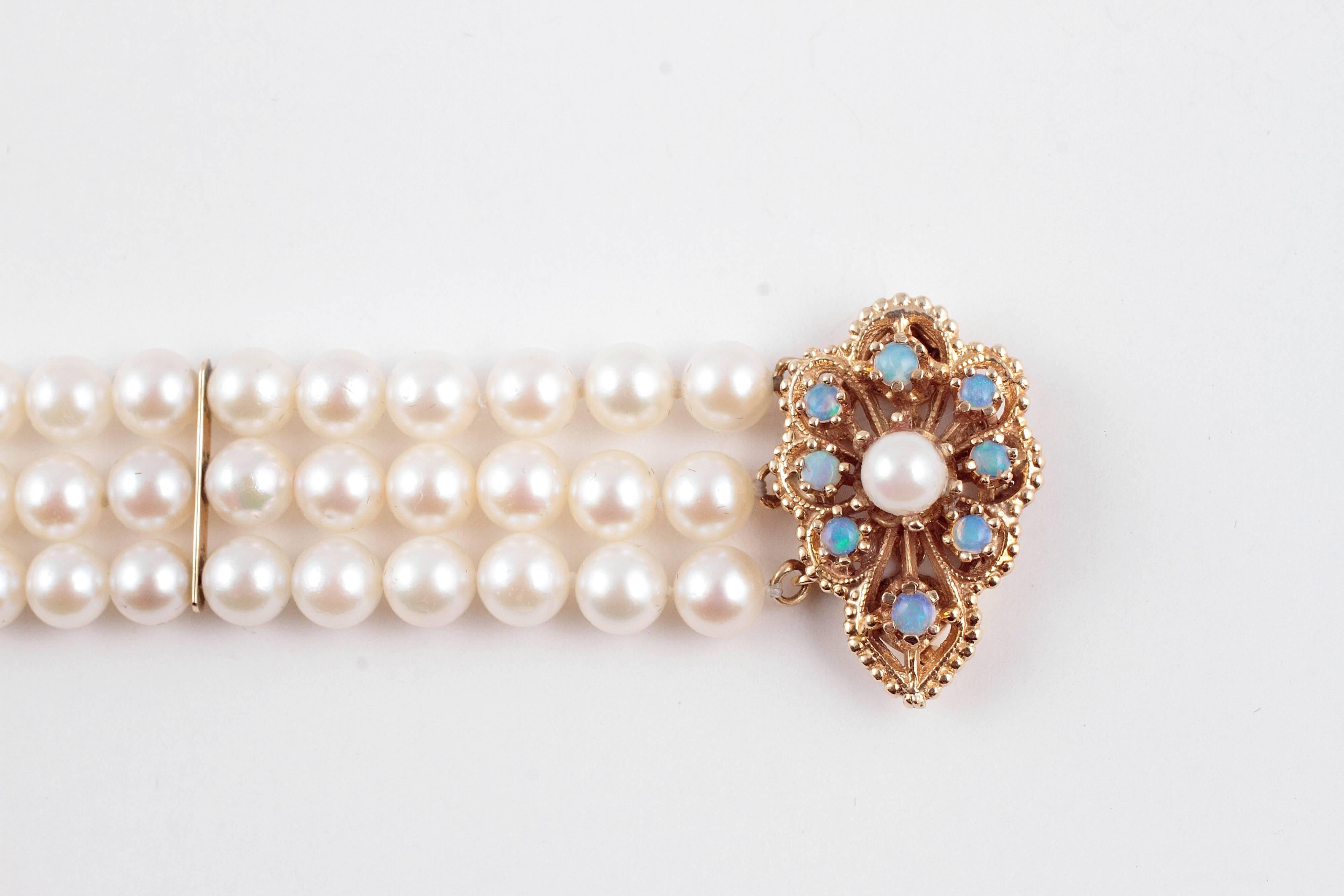 Beautiful and timeless!  This three strand, cultured pearl bracelet is secured with a 14 karat yellow gold, opal and pearl clasp.  