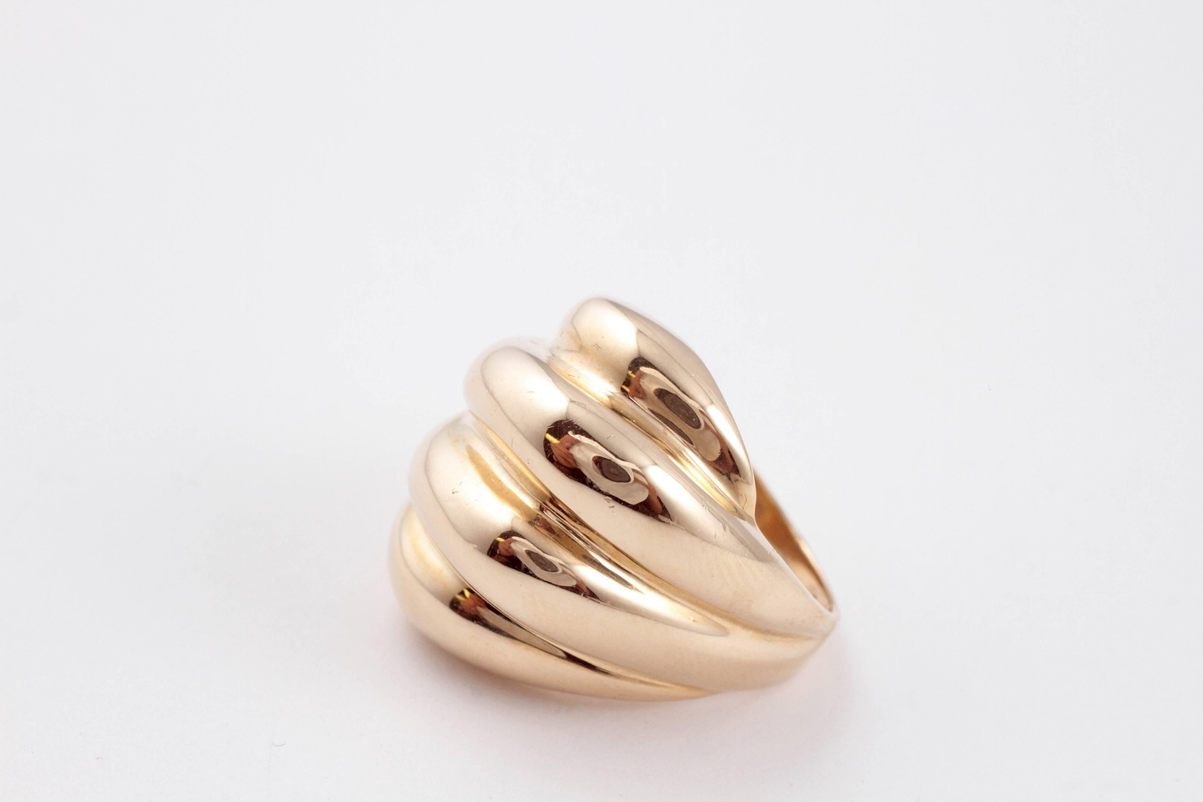 In a 14 karat, yellow gold, highly polished, fluted form, perfect for every day!  Size 5 1/2