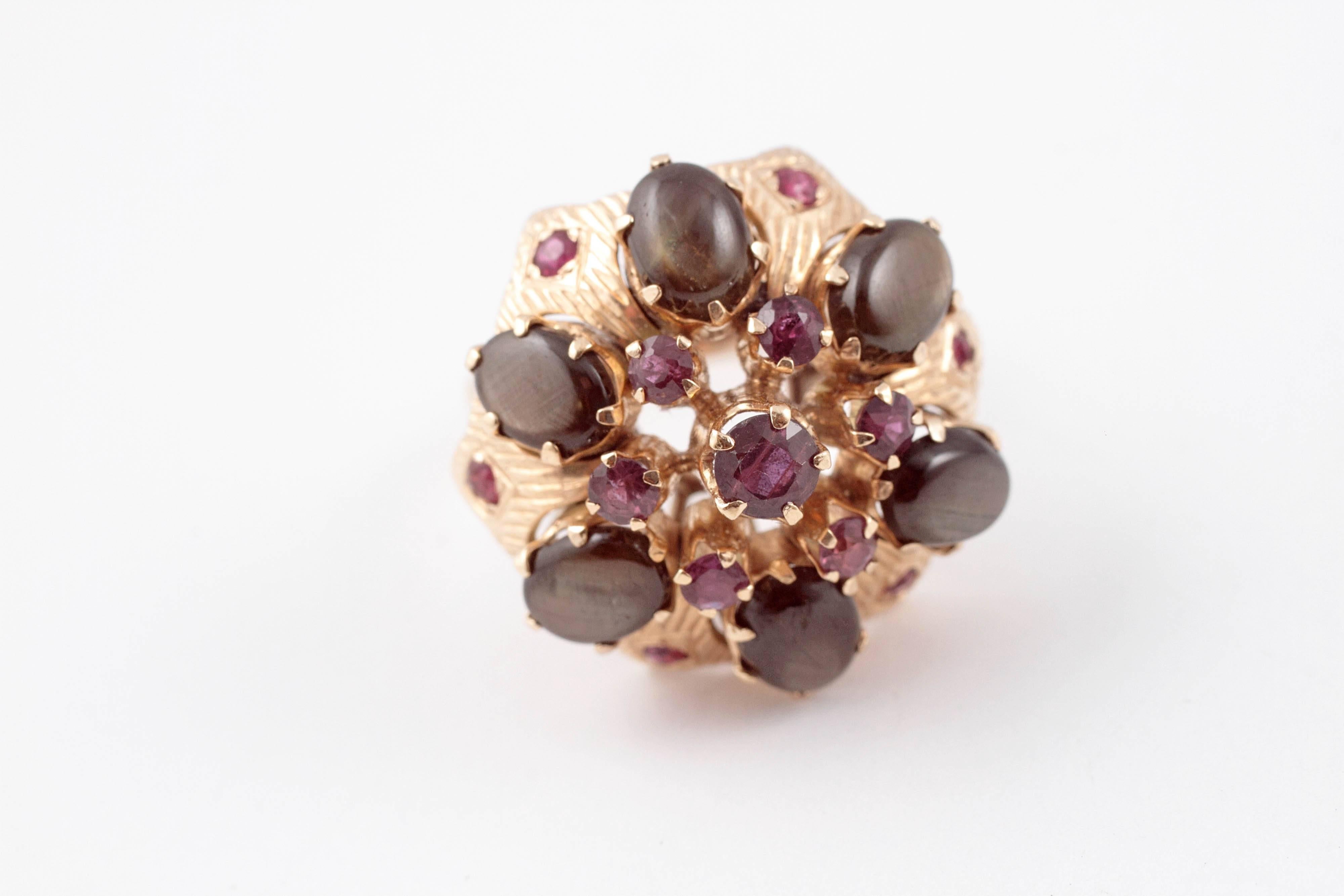 Black star sapphires and rubies adorn this 18 karat yellow gold flower-style ring. Size 7 3/4.
