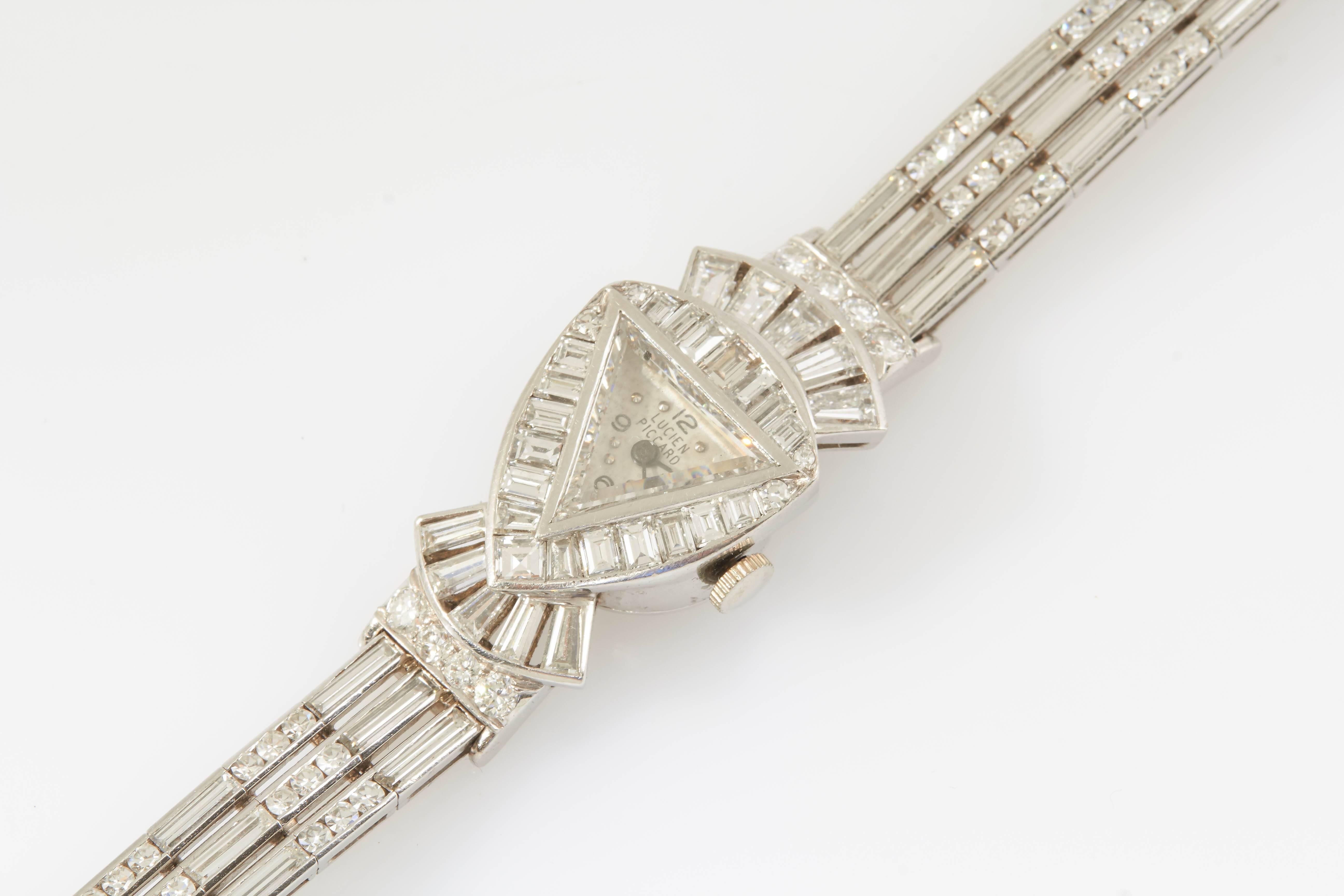 Die signierte Uhr von Lucien Piccard besteht aus Diamanten im Baguette- und Rundschliff mit einem Gesamtgewicht von etwa 20,50 Karat. Das Zifferblatt wird durch ein dreieckiges Diamantglas geschützt. 

