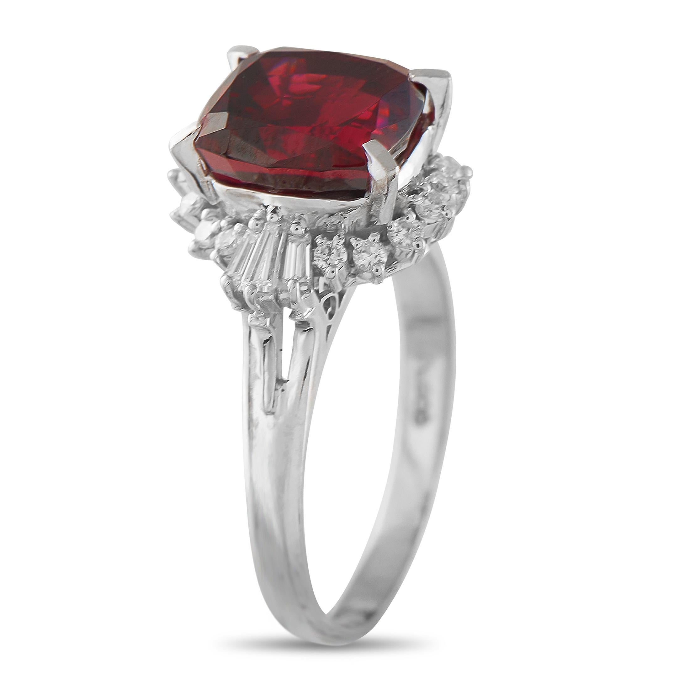 Un granato vivido è al centro della scena, fissato in griffe di platino e accentuato da una combinazione di diamanti tondi e baguette affusolati. La brillantezza e la lucentezza a specchio permettono alla ricca tonalità rossa della gemma centrale di