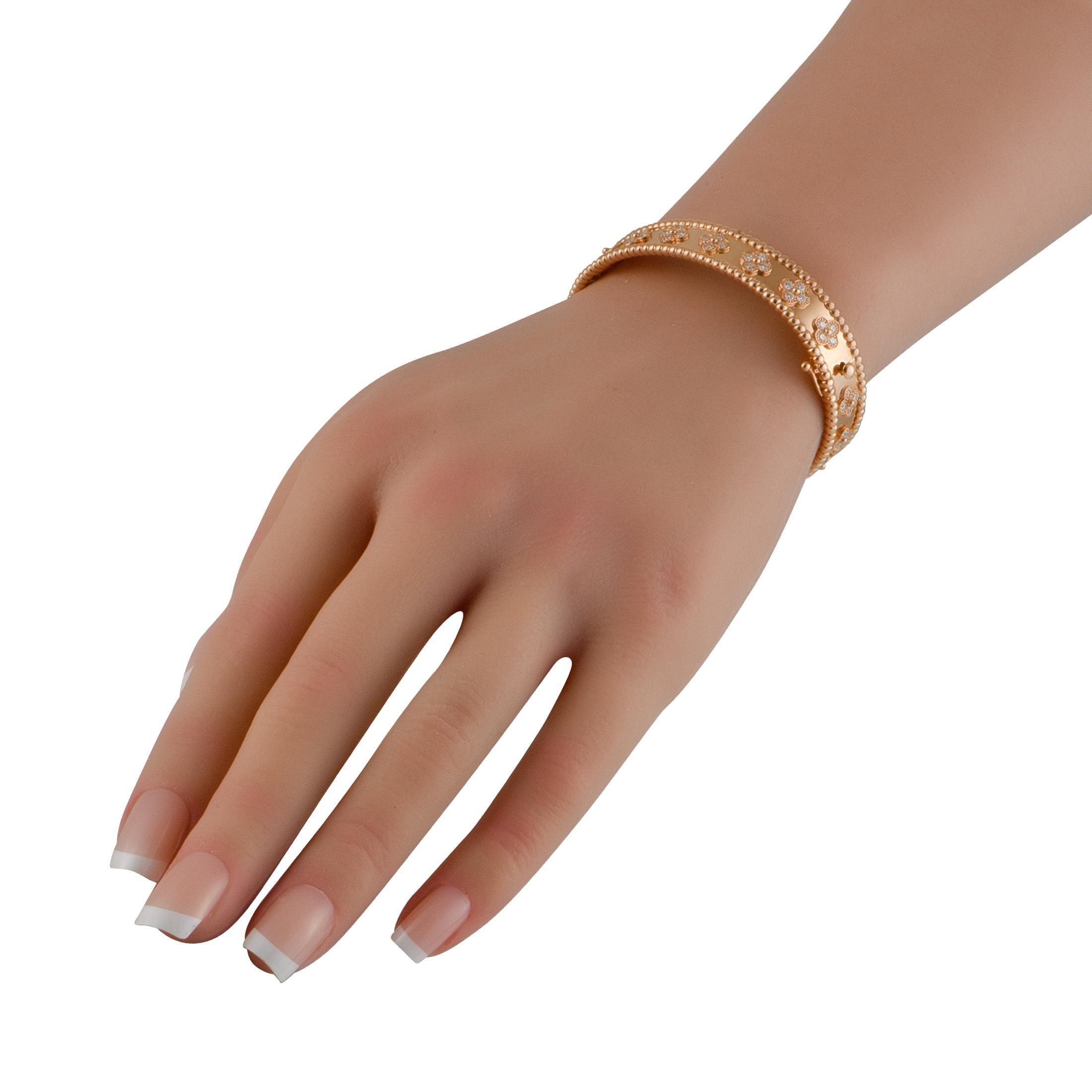 El modelo pequeño de pulsera Tréboles de Perle de Van Cleef & Arpels está elaborado en oro rosa de 18 quilates. Los bordes presentan el icónico diseño de cuentas de la marca. Los diamantes dispuestos en tréboles de cuatro hojas recorren la