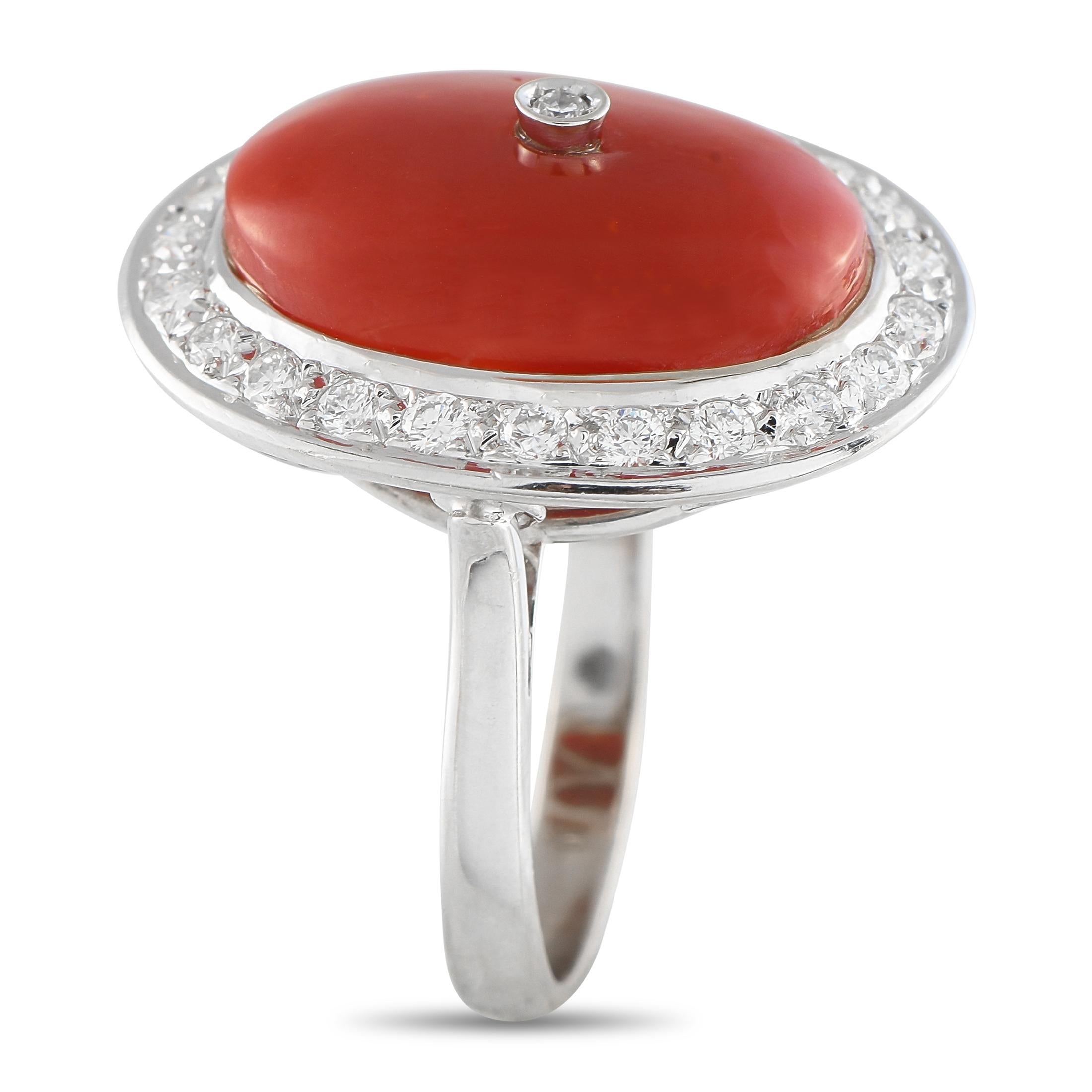 Un'abbagliante con una storia. Questo anello in oro bianco, in condizioni di tenuta, brilla con un tocco vintage. È realizzato in oro bianco 18 carati e sormontato da un audace corallo cabochon di forma ovale. Un'aureola ovale di 0,65 carati di