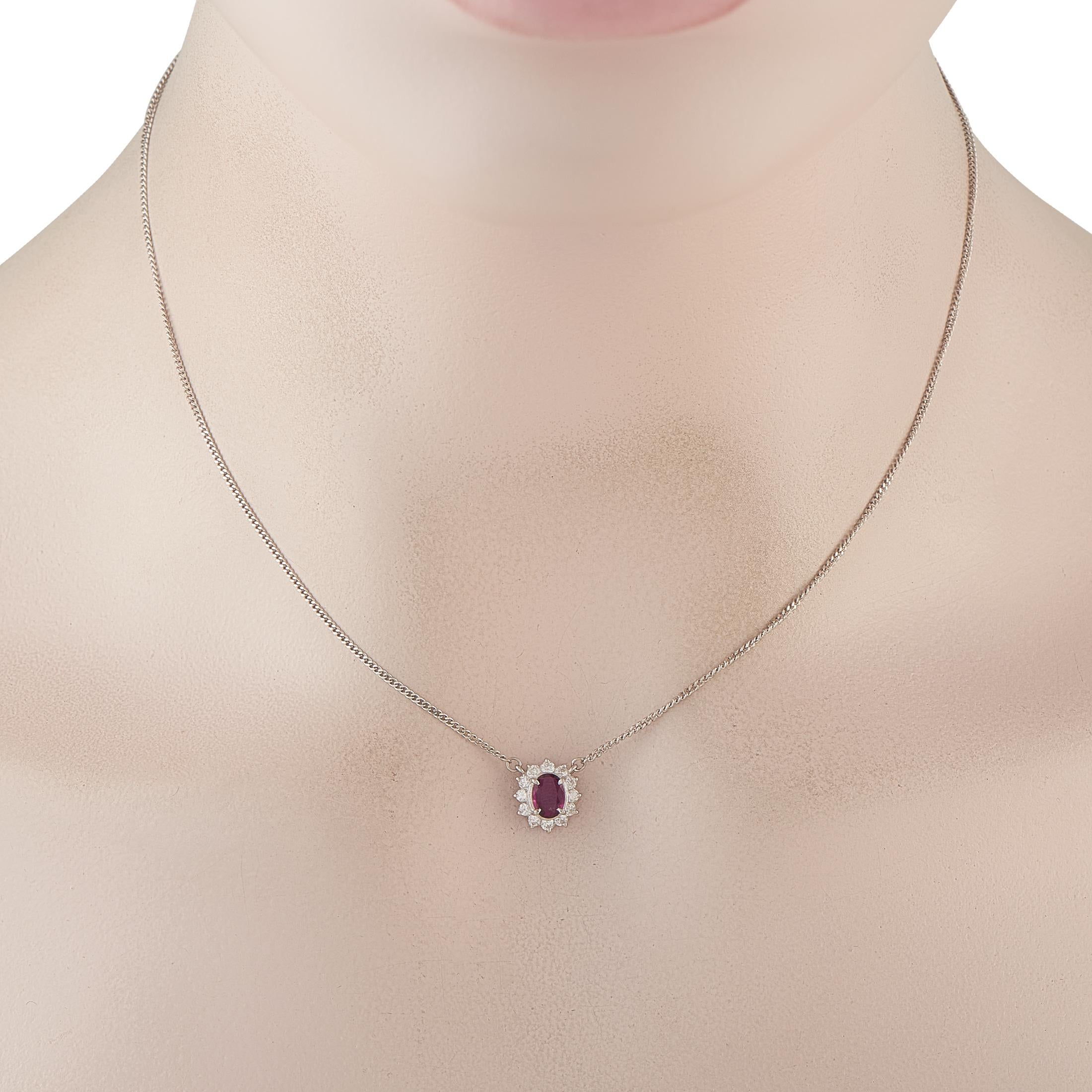 Réalisé en platine, ce collier incarne l'élégance d'antan tout en affichant une sobriété moderne. Il présente un rubis ovale entouré de diamants ronds brillants. Les diamants forment un halo en forme de soleil, les griffes s'étendant légèrement vers