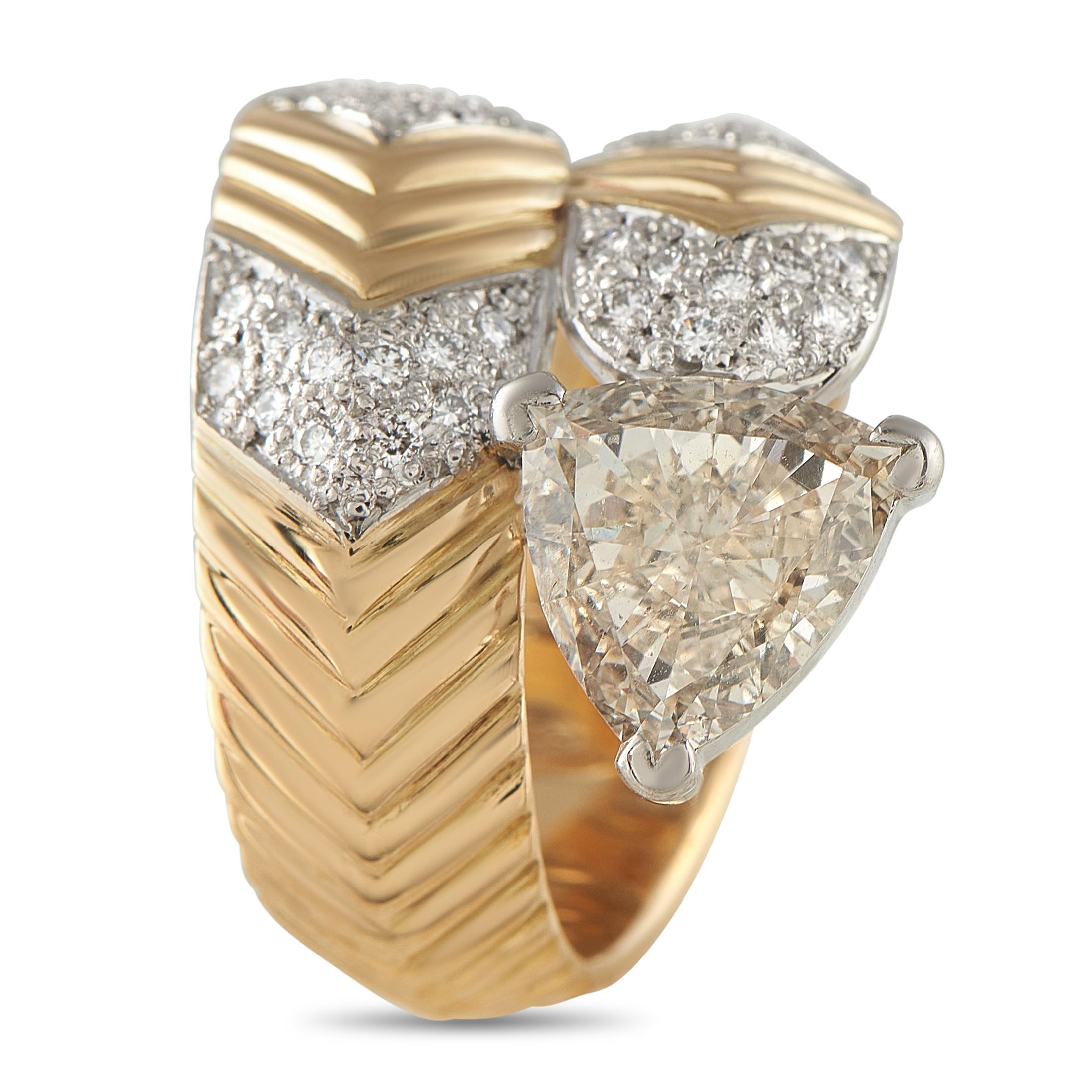 Un design enveloppé rend cette bague de luxe tout simplement inoubliable. La monture texturée en or jaune 18 carats prend vie grâce à une série de diamants sertis étincelants totalisant 0,35 carats. Un diamant trillion de 1,44 carat ajoute un éclat
