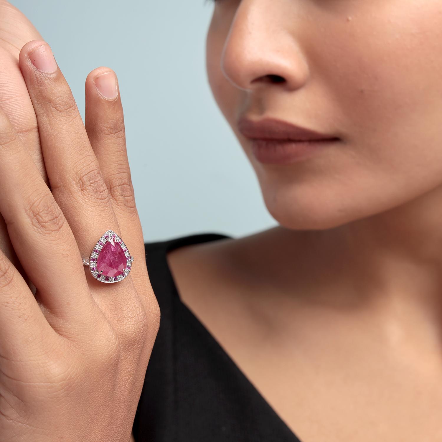Dieser feurige und kühne Cocktailring zeigt einen reichen birnenförmigen Mosambik-Rubin, der von glitzernden Pavee-Diamanten eingerahmt wird. Der aus leuchtendem 14-Karat-Weißgold gefertigte Schmuck ist ein Statement - voller Leidenschaft, Eleganz