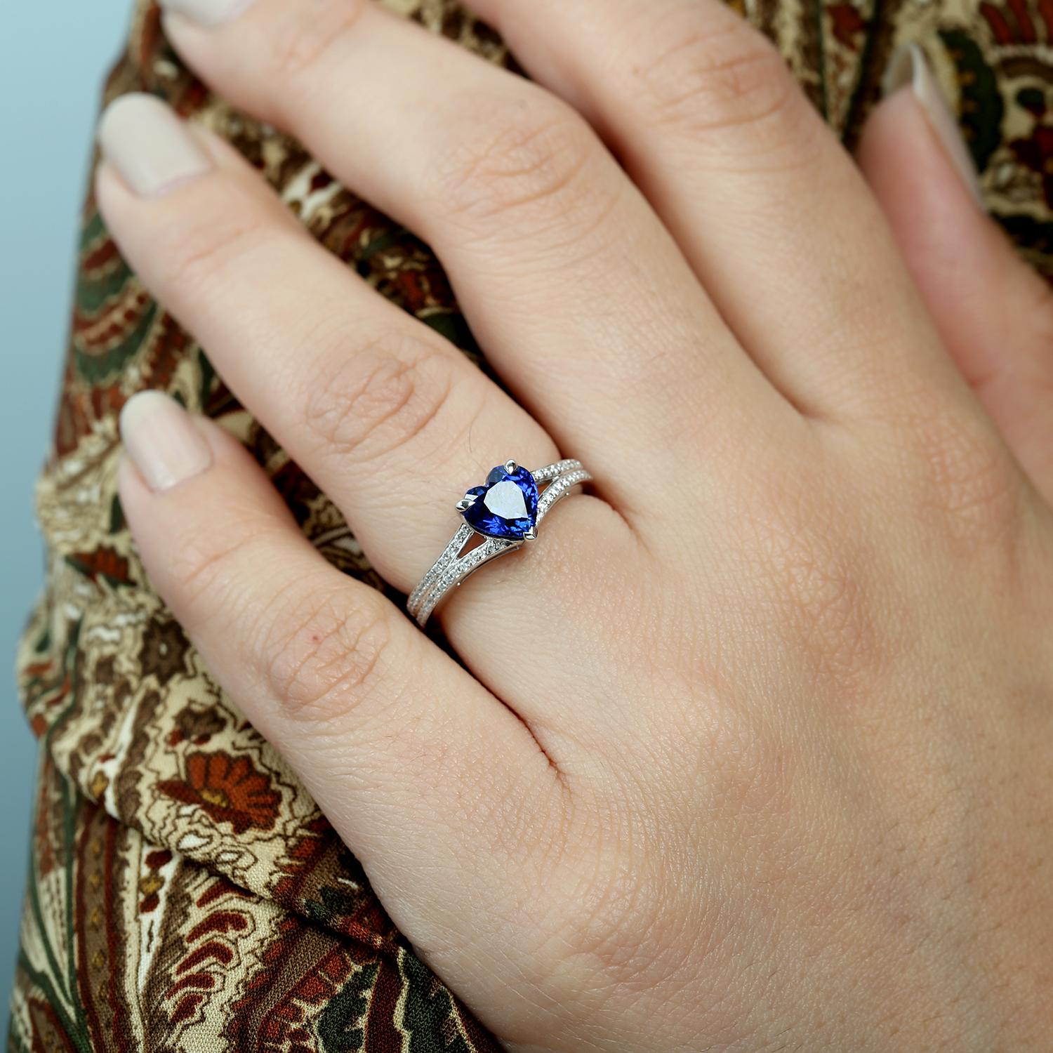 Anello a fascia con cuore in oro bianco 18KT e zaffiro blu di Ceylon con diamanti
Romantico con un tocco raffinato, questo anello a fascia presenta un sorprendente zaffiro blu di Ceylon a forma di cuore accentuato da delicati diamanti. Incastonato