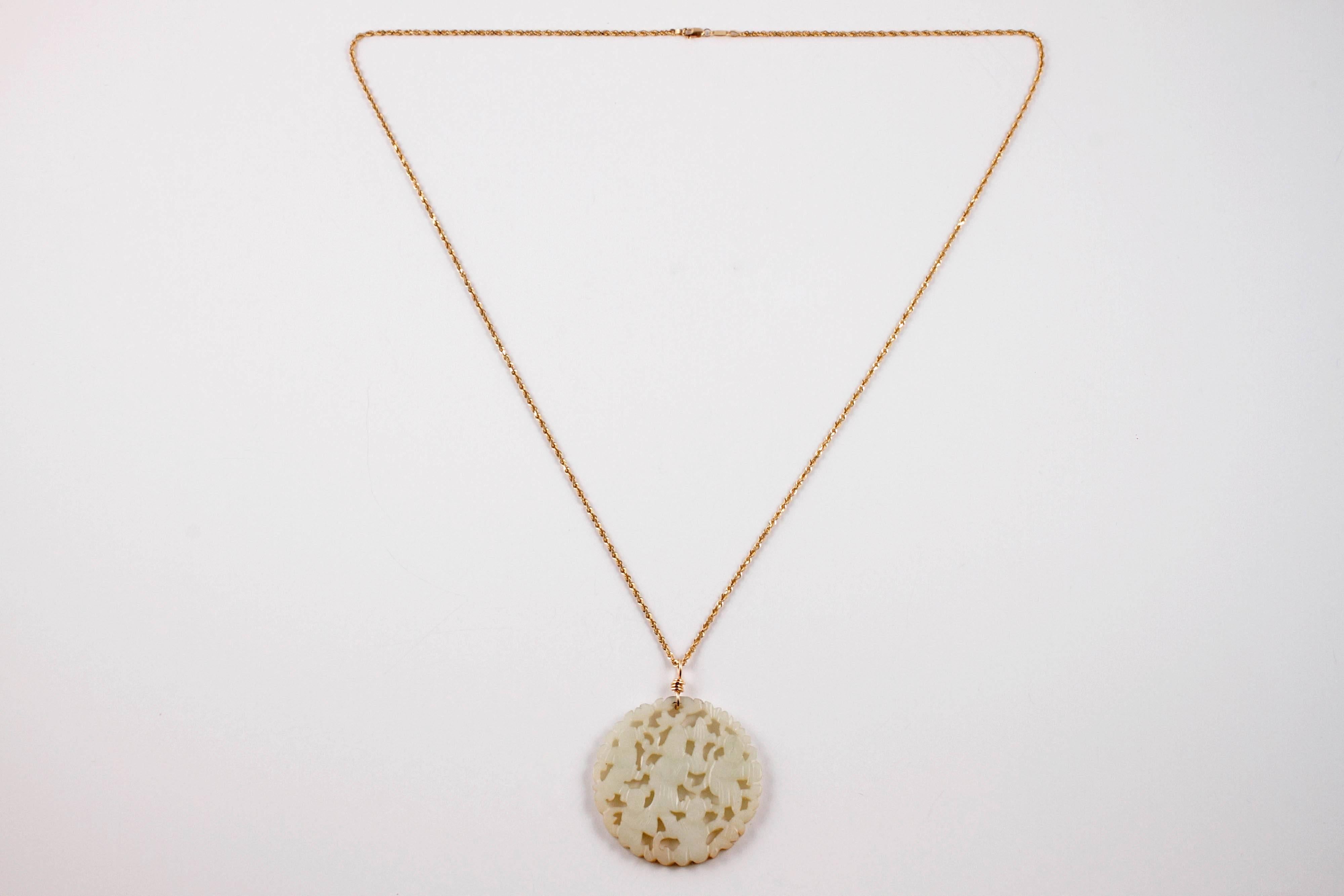 Intricately carved nephrite jade pendant on a 30 inch 14 karat gold chain.