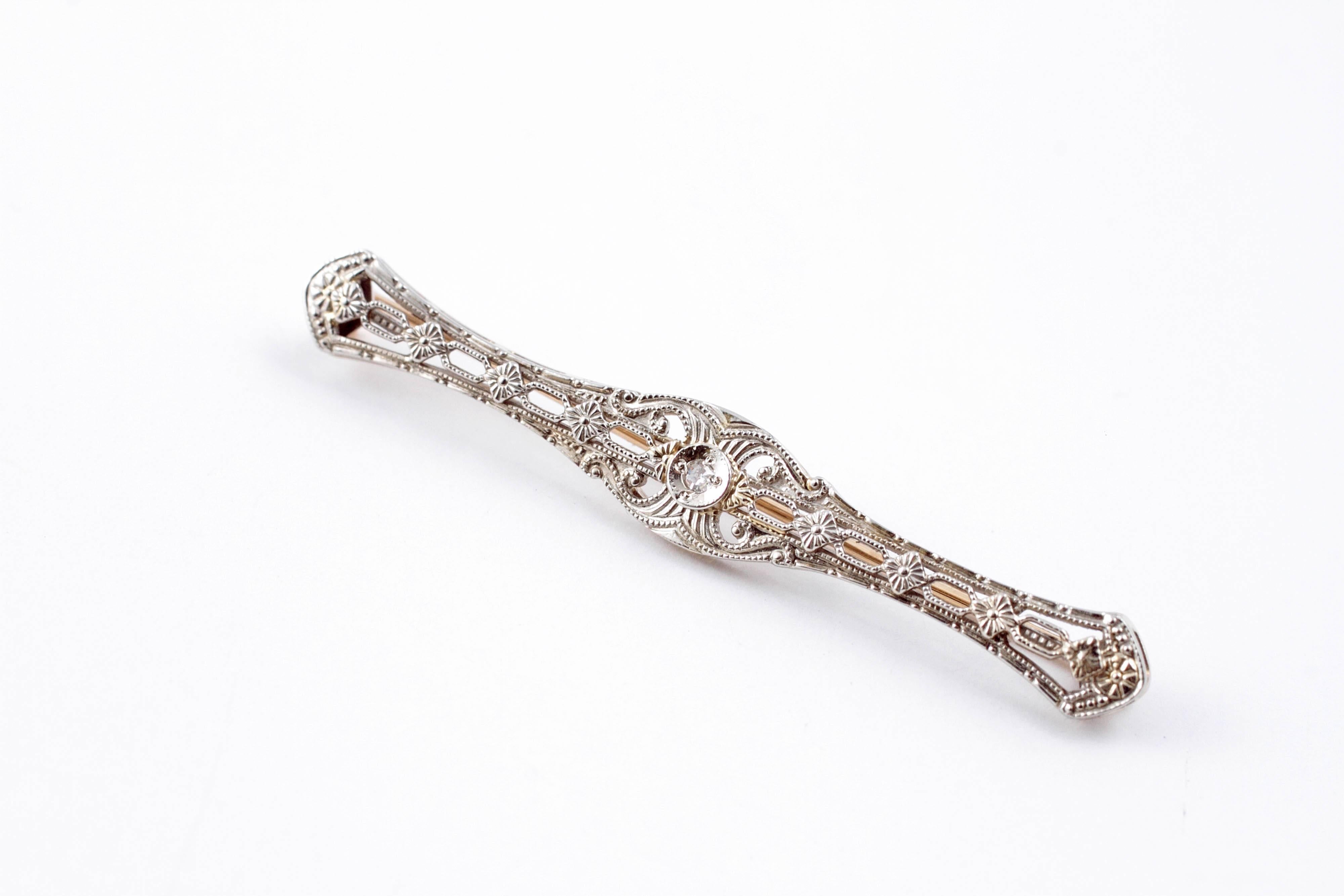 Intricate diamond bar pin set in 14 Karat yellow and white gold.  Measuring approximately 2 1/4 inches in length. 