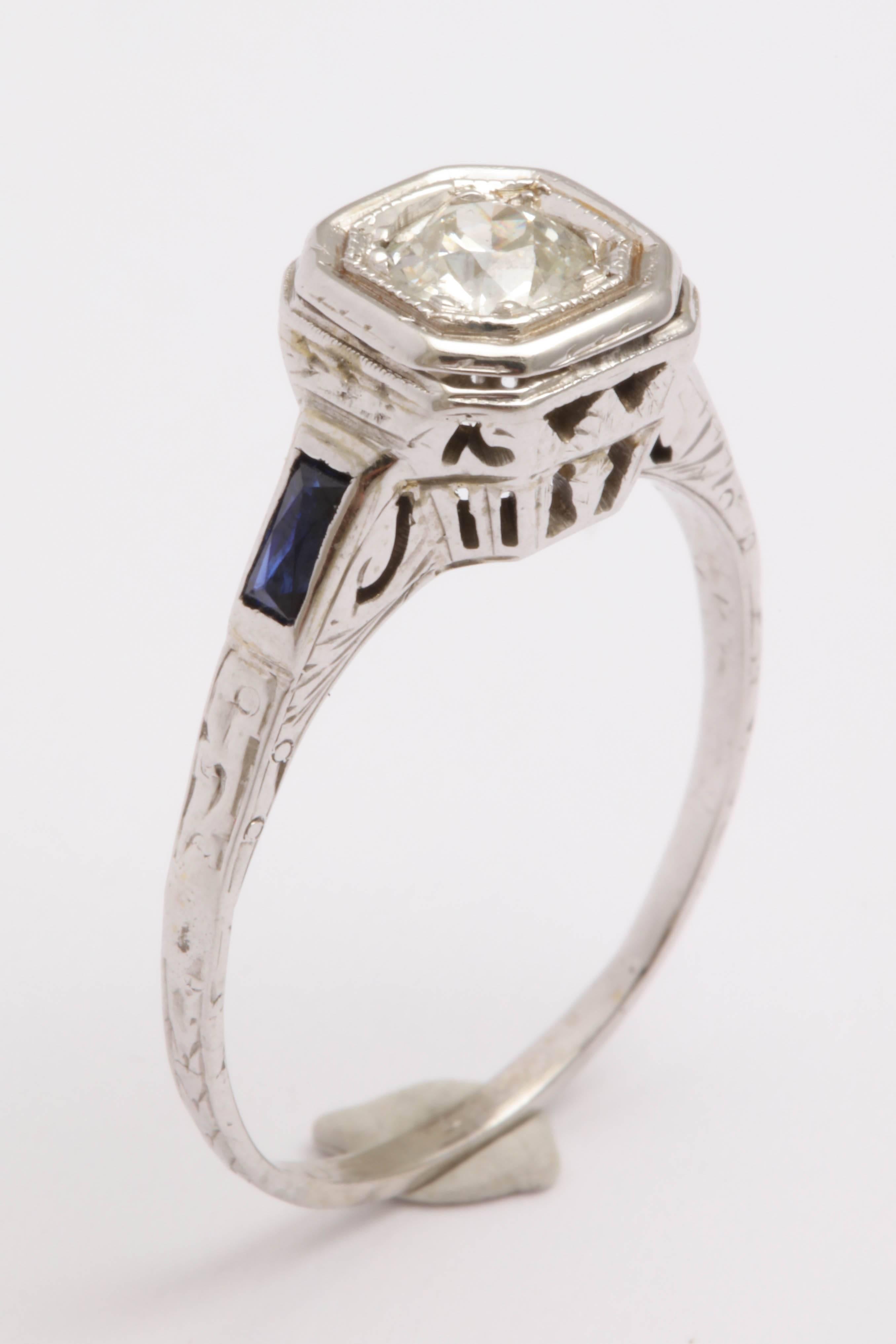 14K white gold diamond and sapphire Art Deco engagement ring. The sapphires are synthetic. Synthetic sapphires were quite popular at the time as the technology to make them had just come about. The center diamond is an Old European diamond set flush
