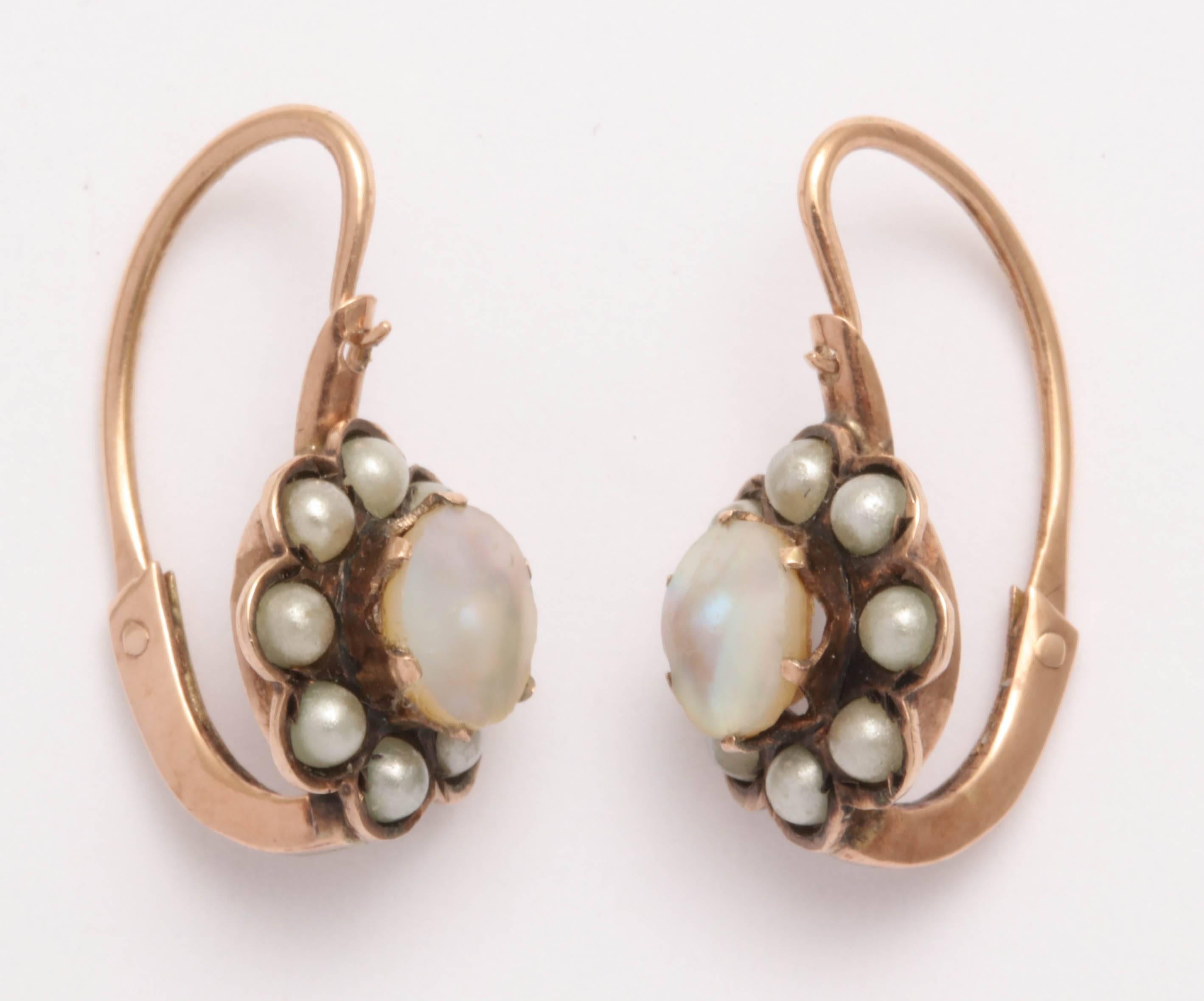 14kt rose gold Victorian earrings with mother of pearl center surrounded by eight seed pearls. Back to front closures. 