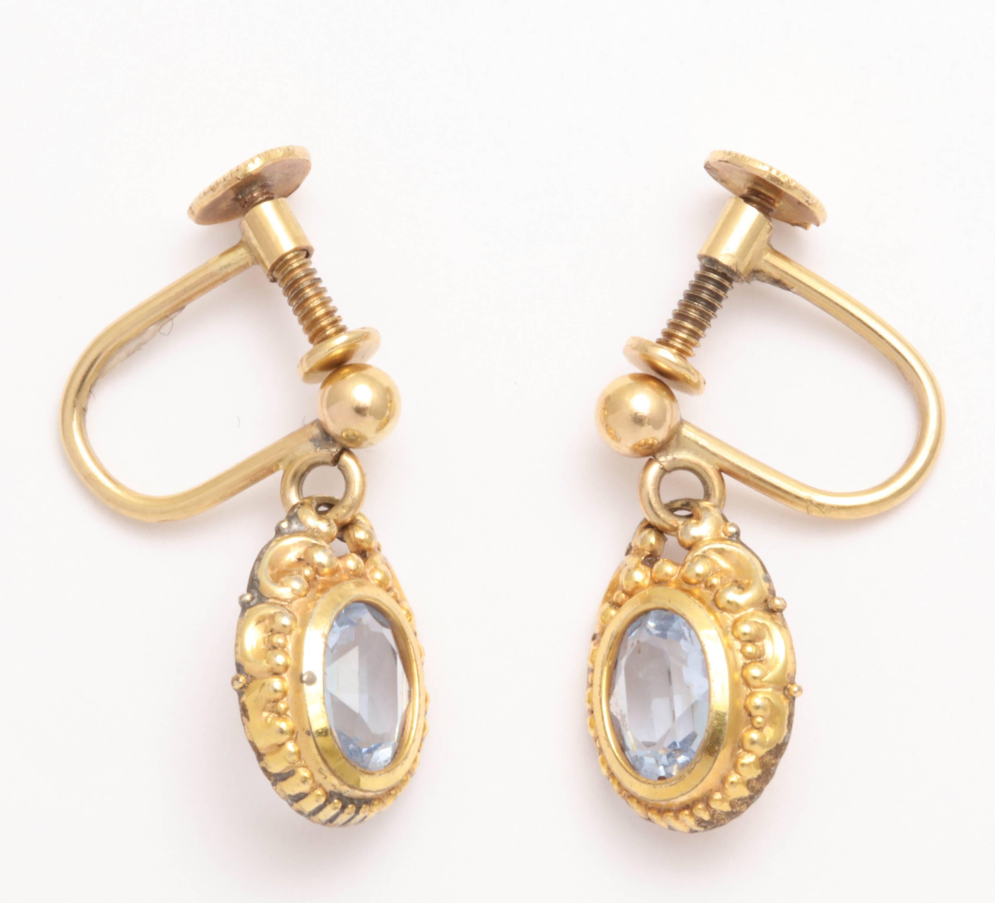 Very sweet aqua earrings dating to the early 20th century. Rolled gold fronts and yellow gold screw backs. Lovely faceted oval aquas. 

They can be changed to posts. 

