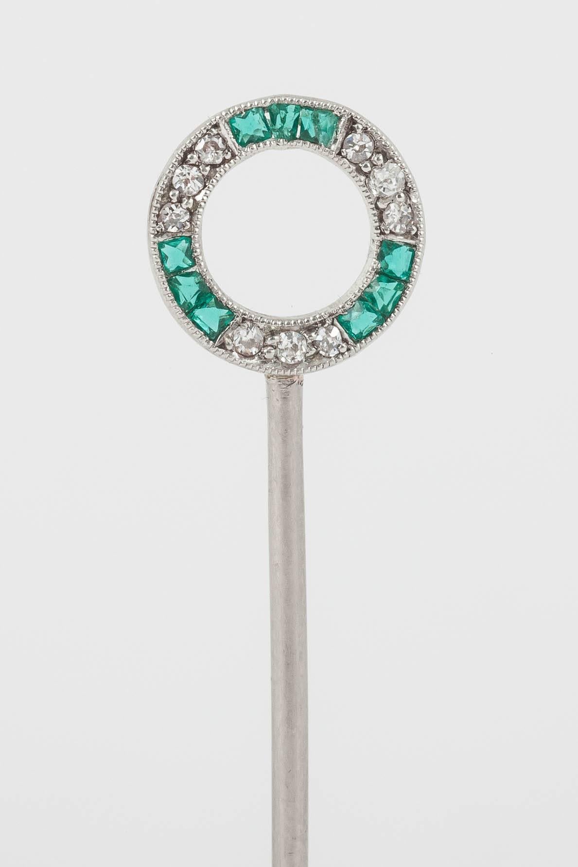 A platinum mounted winning post tiepin set with brilliant cut diamonds and calibre set emeralds. English c, 1900-10