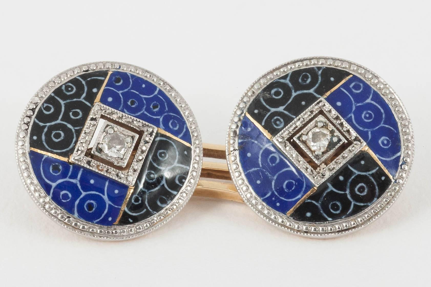 An unusual pair of 18ct gold double sided cufflinks with a central diamond and blue and black enamel quarters with white enamel circles. English c , 1920