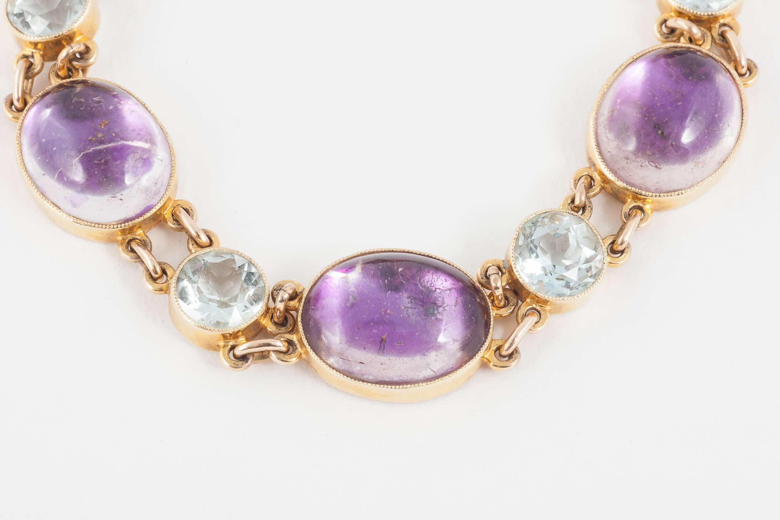 This bracelet in 15ct is set with alternating cabochon cut foiled Amethysts and round Aquamarines in rub over settings.
