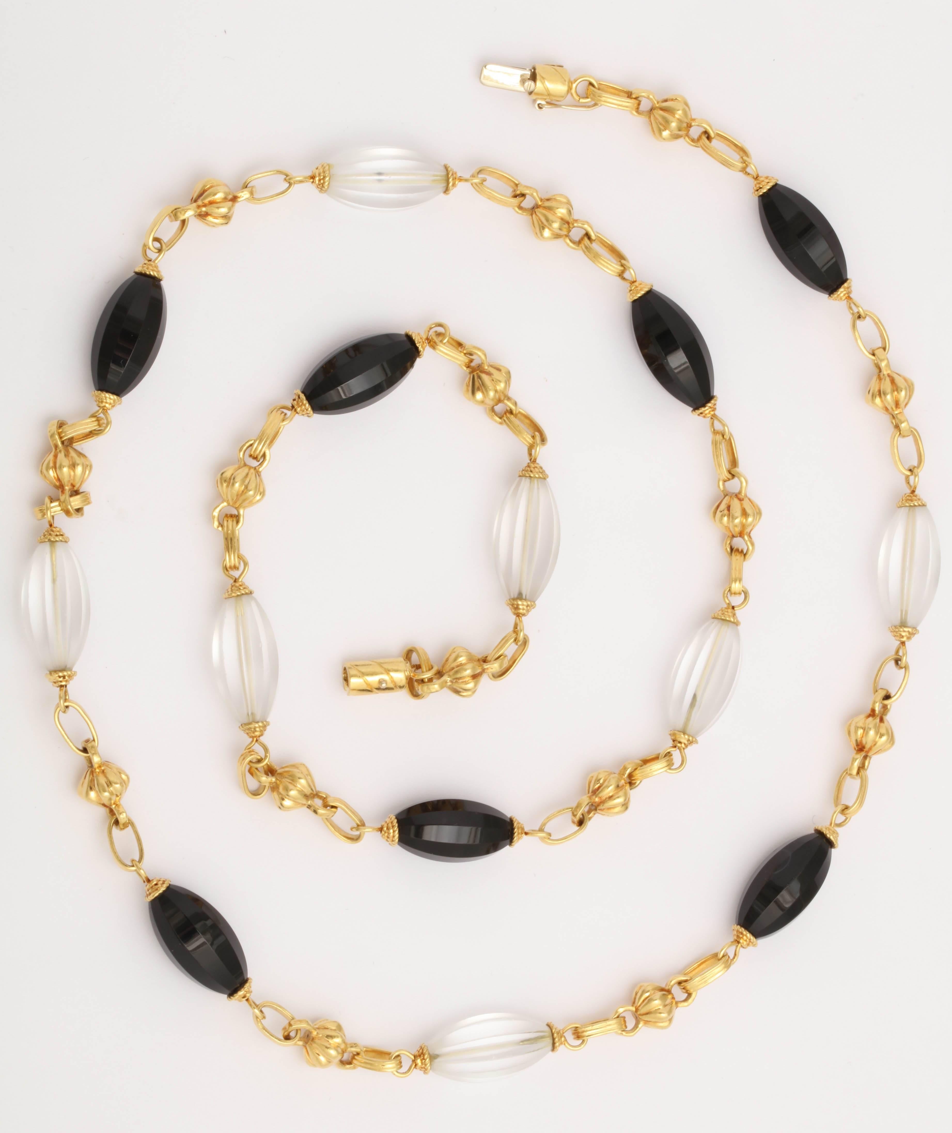 Chic long chain in 18kt Yellow Gold interspersed by 18kt YellowGold elements , 7 faceted Black onyx Beads & 7 melon shaped Rock Crystal Beads. Signed SF & dated 1970.  34.5" long - can be worn singly with other chains  or beads or  and