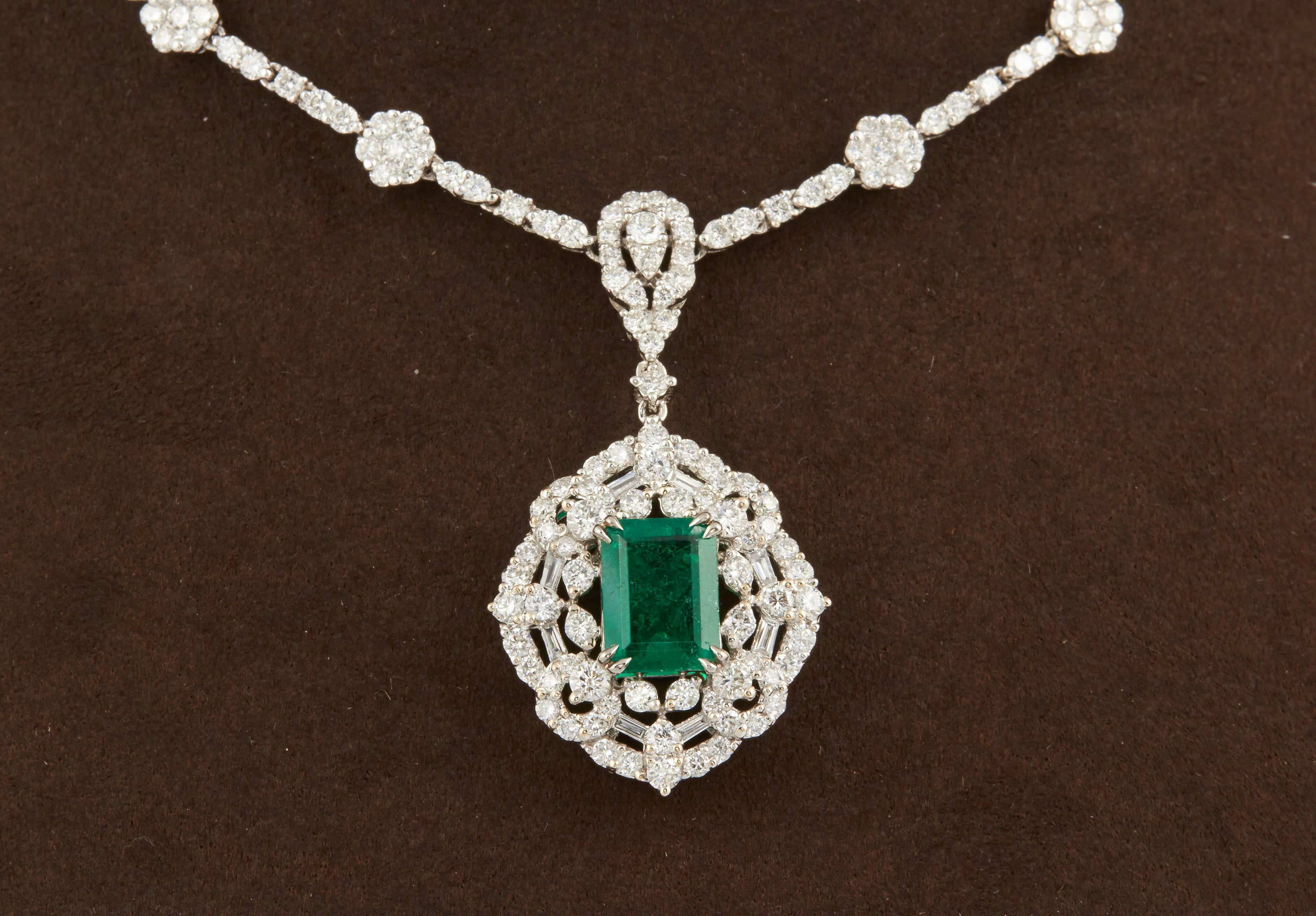 

Un superbe collier d'émeraudes vertes et de diamants au design classique. 

Émeraude verte de 1,84 carat certifiée GIA et taillée en émeraude.

L'émeraude est entourée de diamants et est suspendue à un collier de diamants de 9,40 carats de couleur