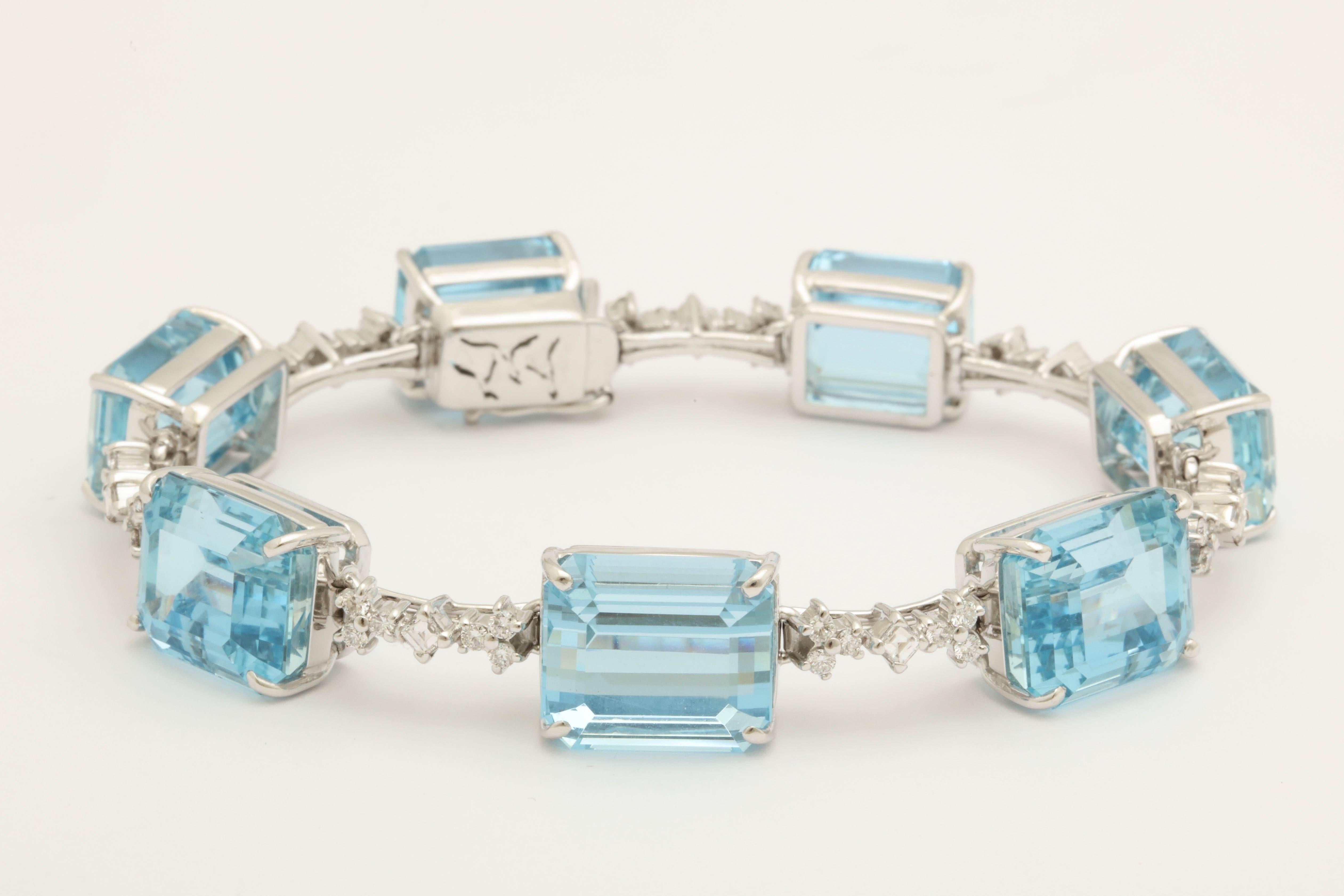 One Ladies 18kt White Gold Flexible Straighline Bracelet Embellished With Seven Rectangular Emerald Cut Gem Quality Aquamarines Weighing Approximately 50 Carats Total Weight, Bracelet Is Further Designed With Brilliant Full Cut Round And Alternating