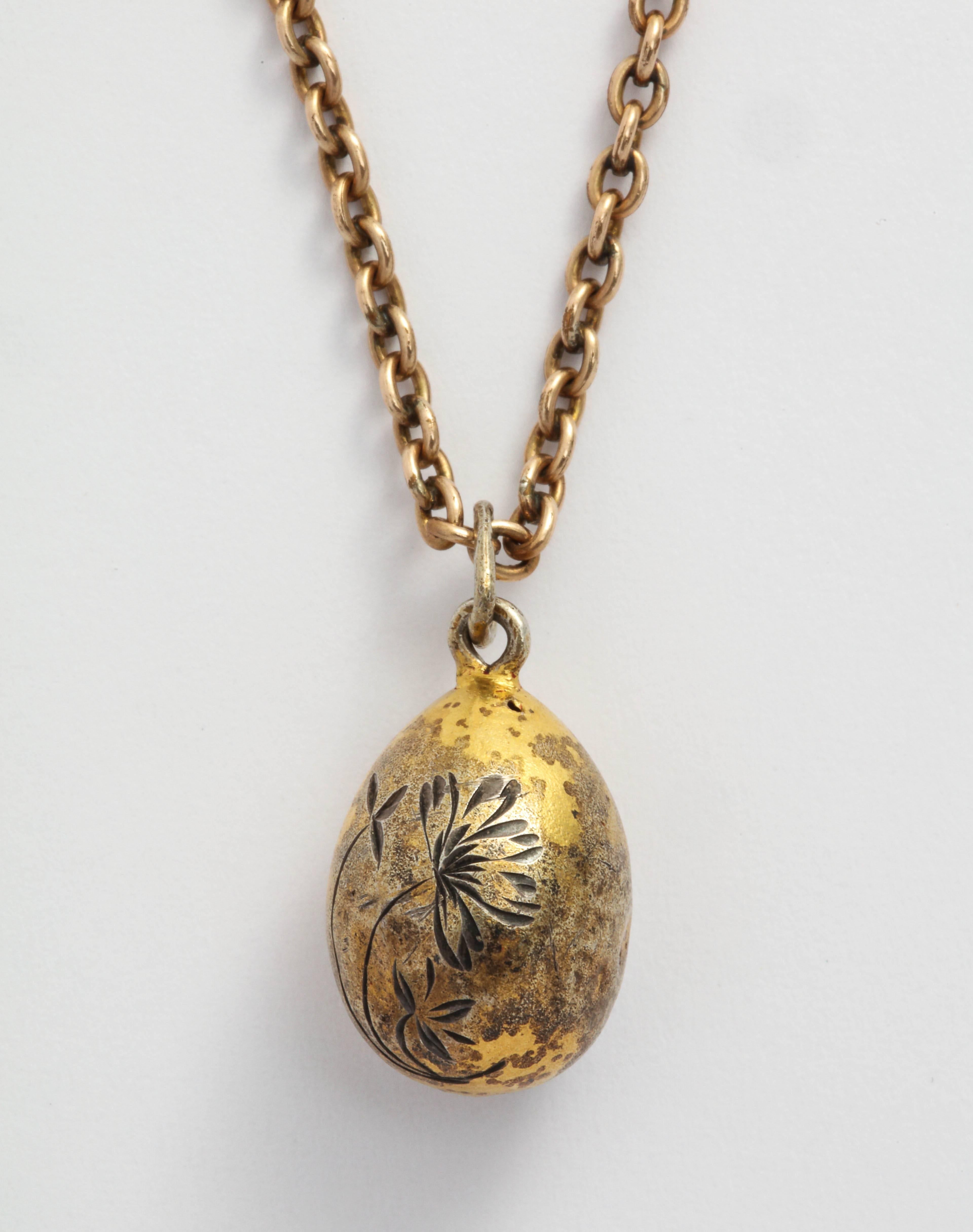 A Romanov era treasure from the period of Tsar Nicholas II, this silver gilt Russian miniature egg pendant is etched with flowers on one side and XB, for the Russian Easter proclamation Xristos Boskrese on the other, with a silver suspension